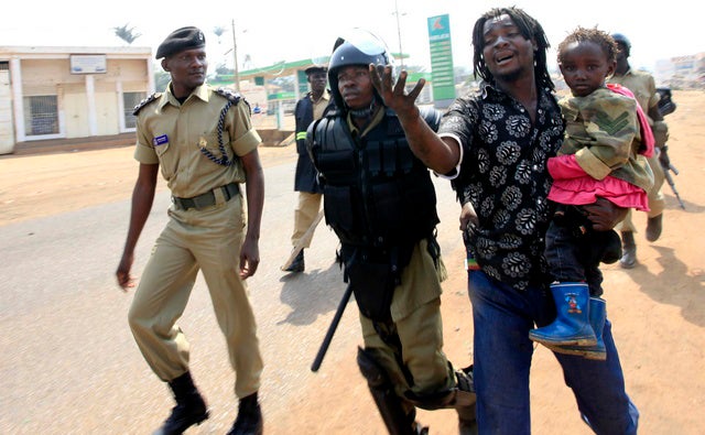 Police arrest a man with a child in a suburb of Kampala on September 11, 2009.