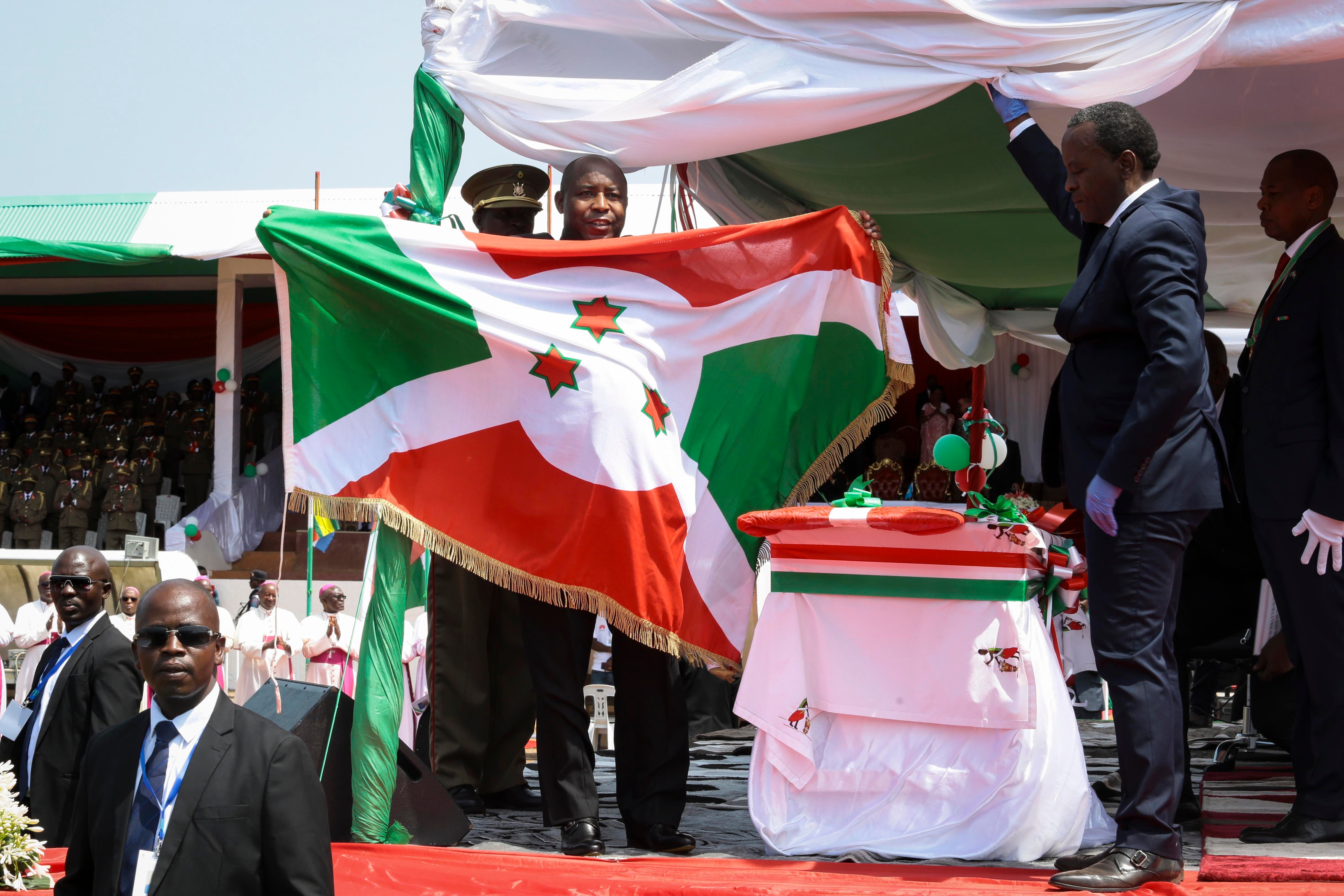 Burundi’s President Evariste Ndayishimiye holds the national flag after his inauguration in Gitega, Burundi, on June 18, 2020. 