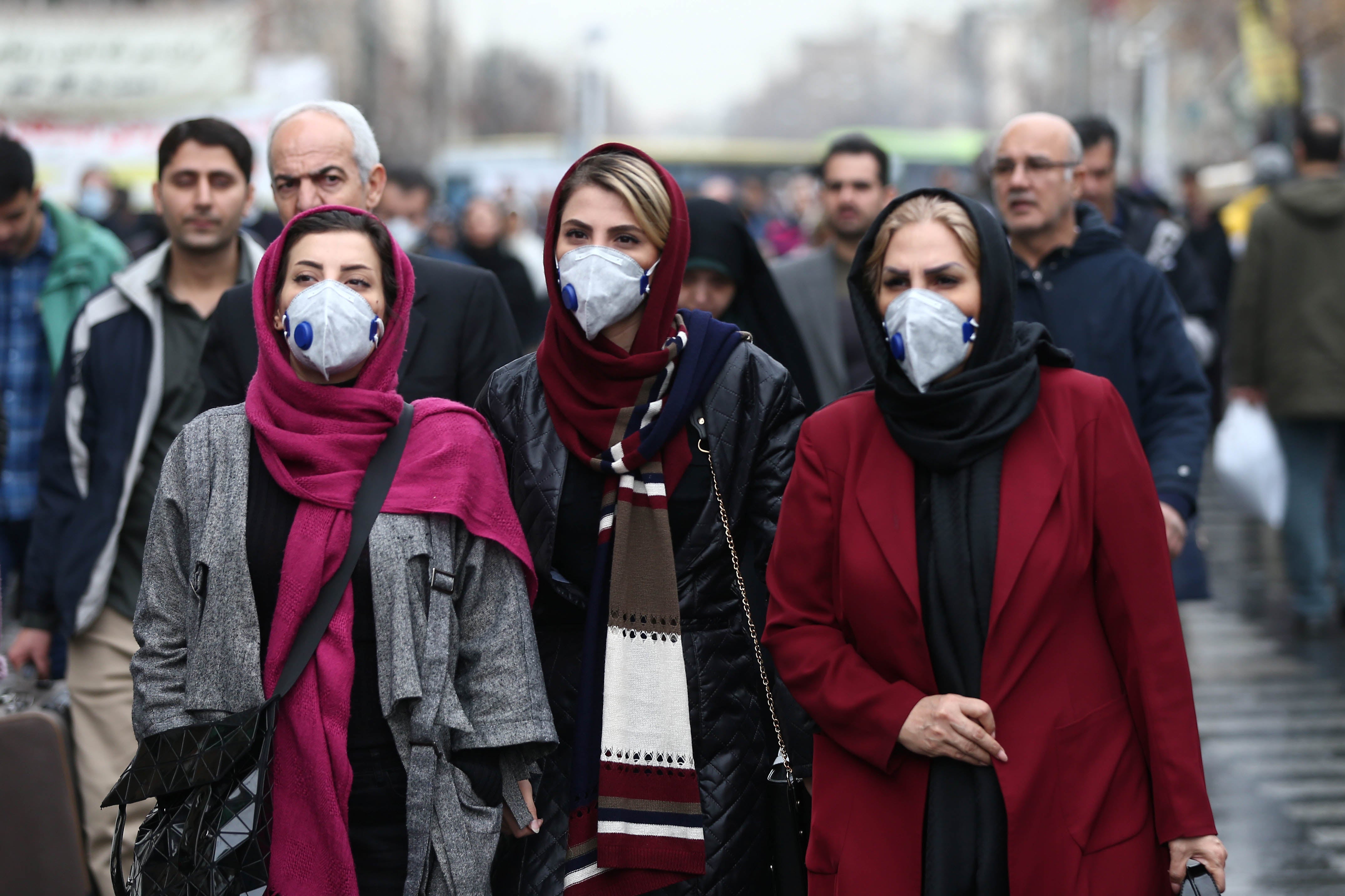 Iranian women wearing masks to protect themselves from the coronavirus walk at the Grand Bazaar in Tehran on February 20, 2020.