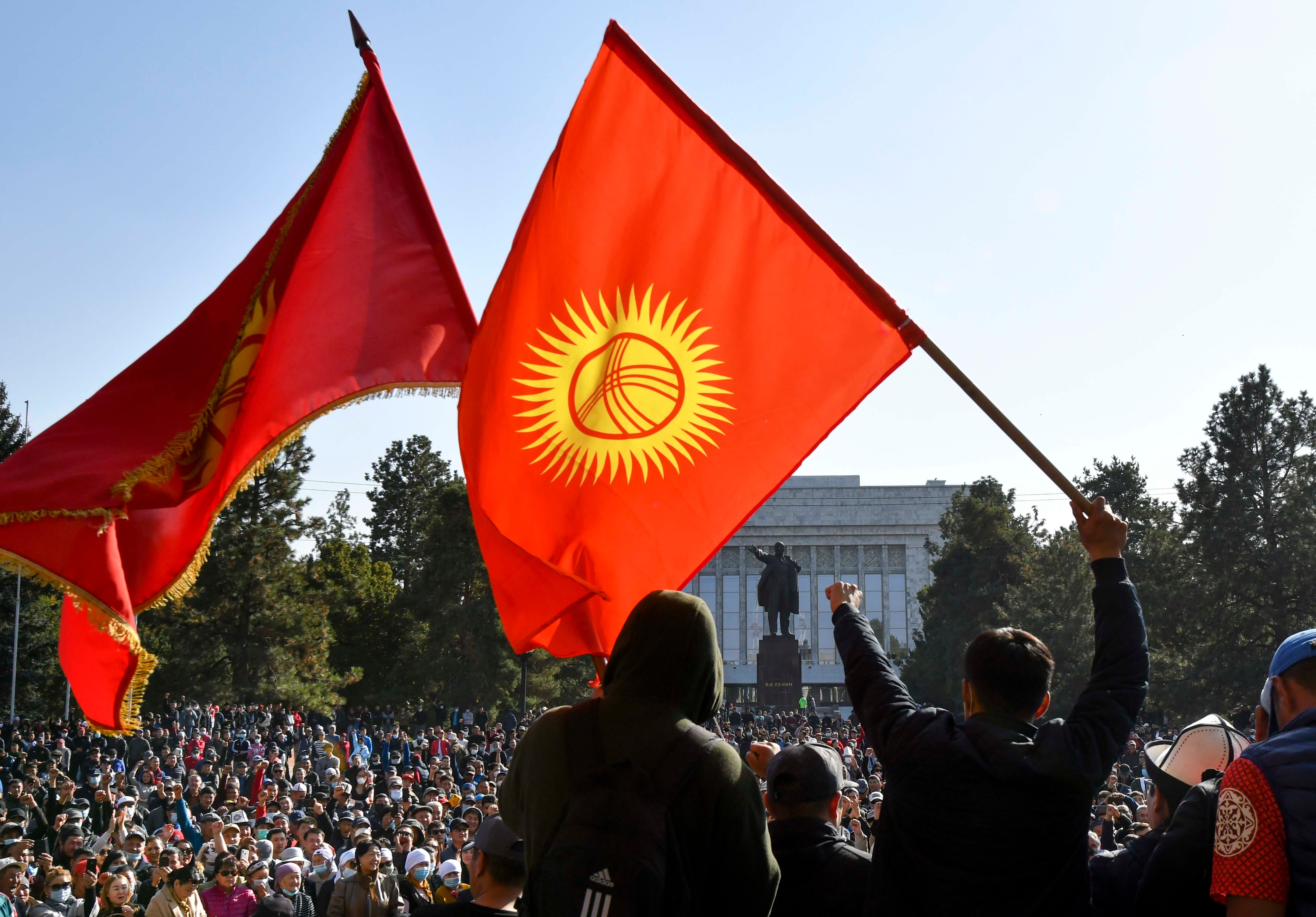Protesters react waving Kyrgyz national flags as they wait for Kyrgyz Prime Minister Sadyr Zhaparov speech in front of the government building in Bishkek, Kyrgyzstan, Wednesday, Oct. 14, 2020.
