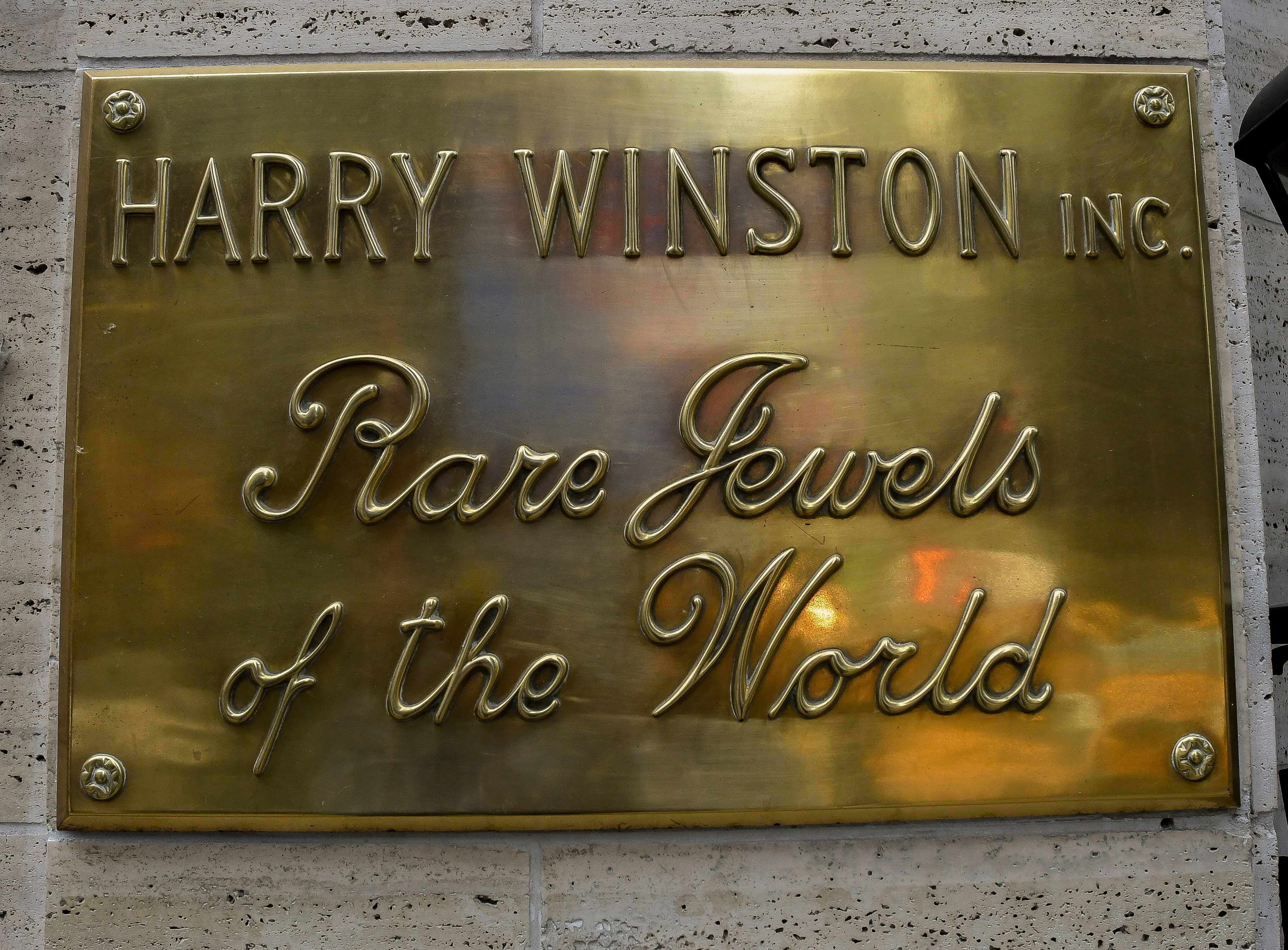 A gold plaque that reads "Harry Winston Inc.: Rare Jewels of the World"
