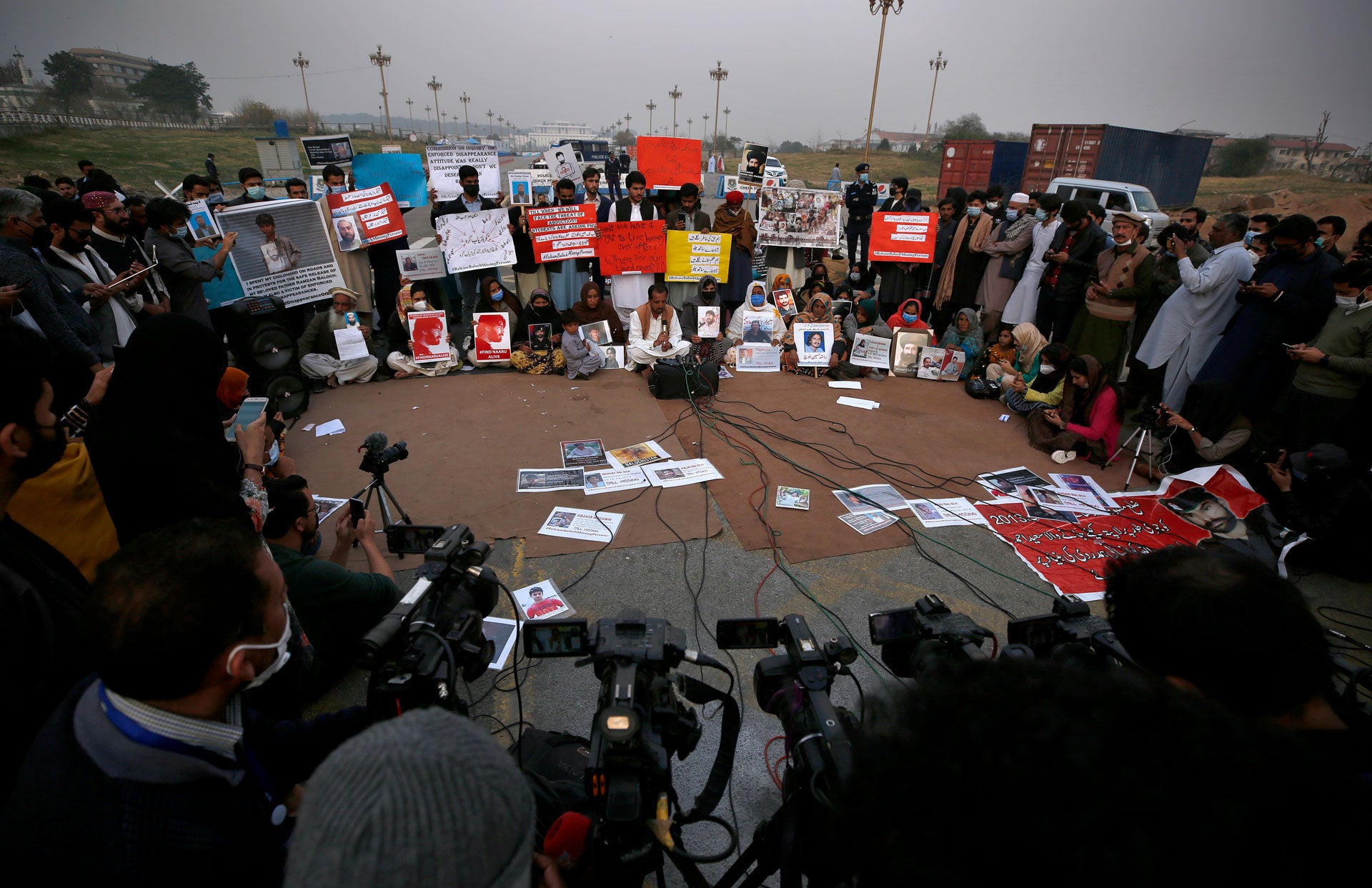 People hold placards and portraits of their missing family members during a press conference in Islamabad, Pakistan, February 20, 2021. 