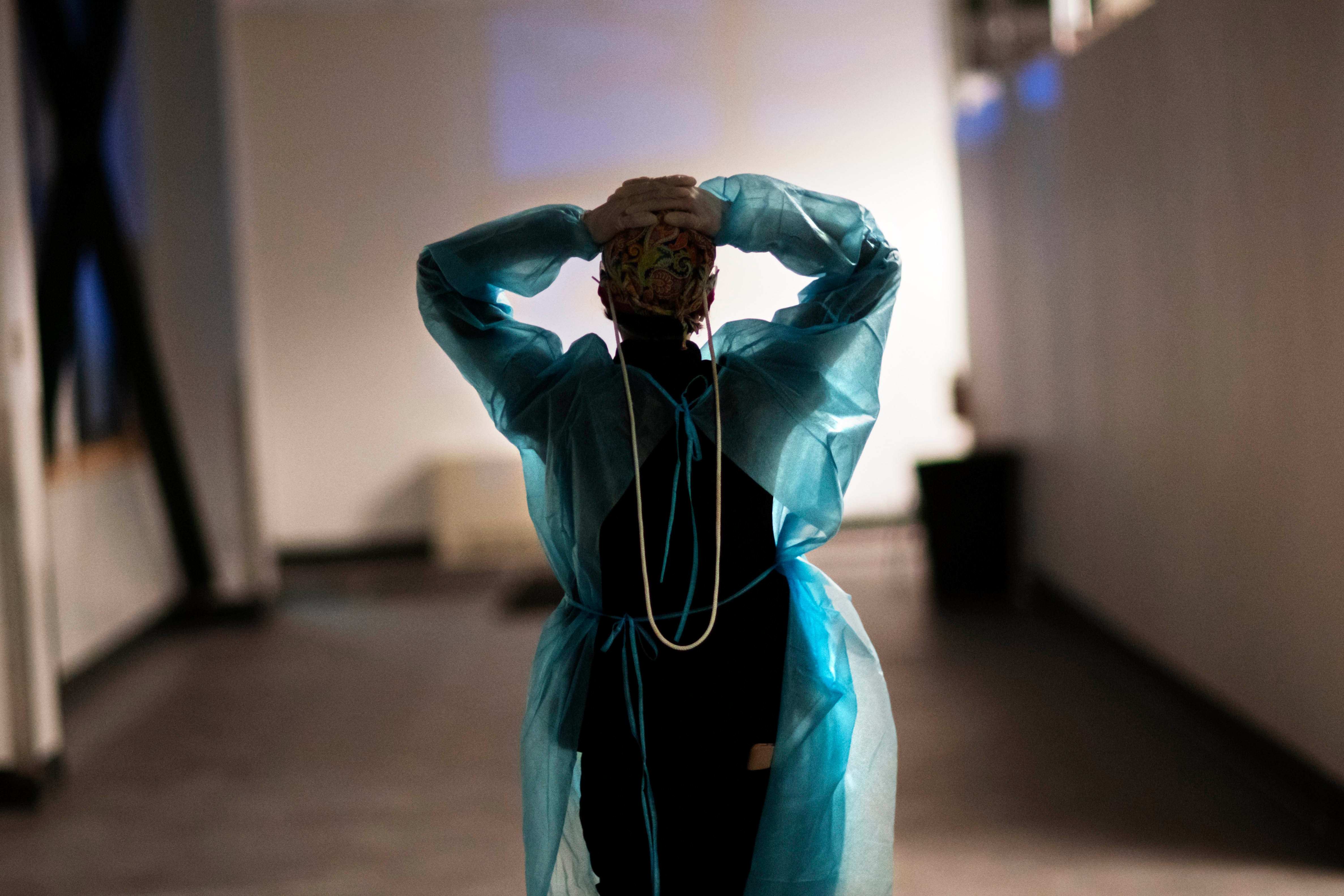 Registered traveling nurse Patricia Carrete walks down a hallway during a night shift at a field hospital set up to handle a surge of COVID-19 patients, Wednesday, Feb. 10, 2021, in Cranston, Rhode Island, US.