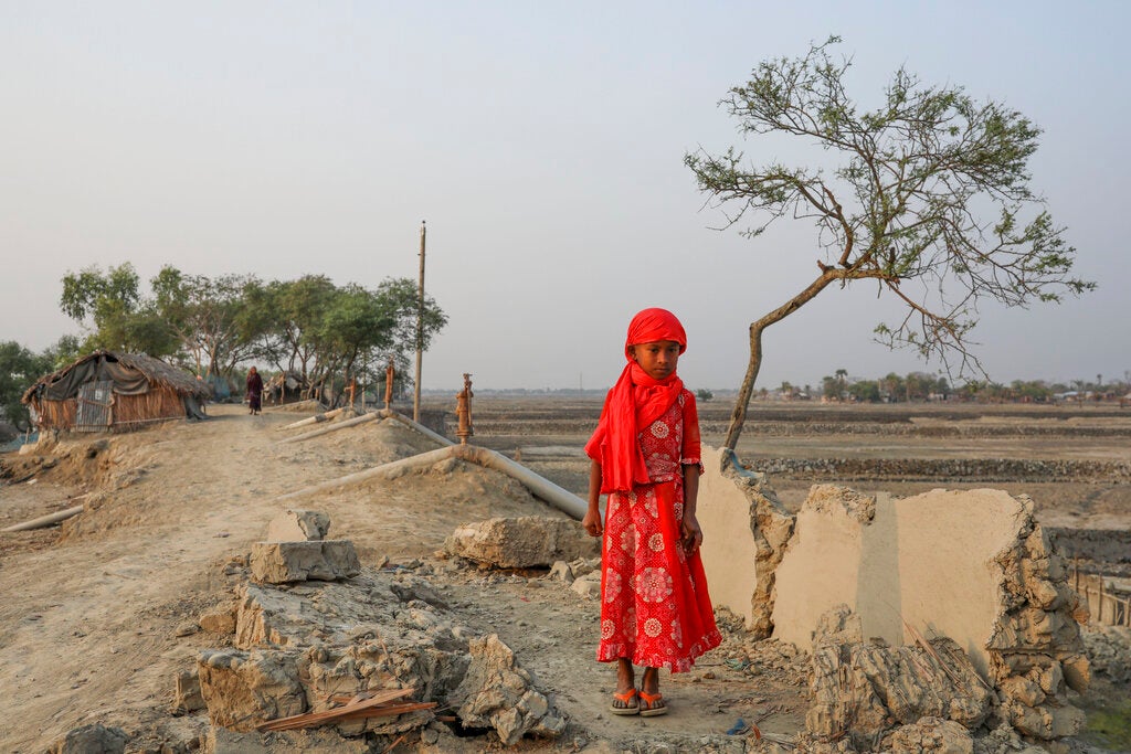A girl surrounded by land devastated by Cyclone Amphan in Satkhira