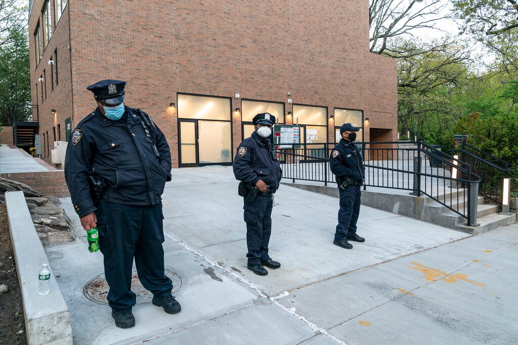 Police stand guard in front of the Young Israel of Riverdale synagogue where glass windows were smashed in New York on April 25, 2021.