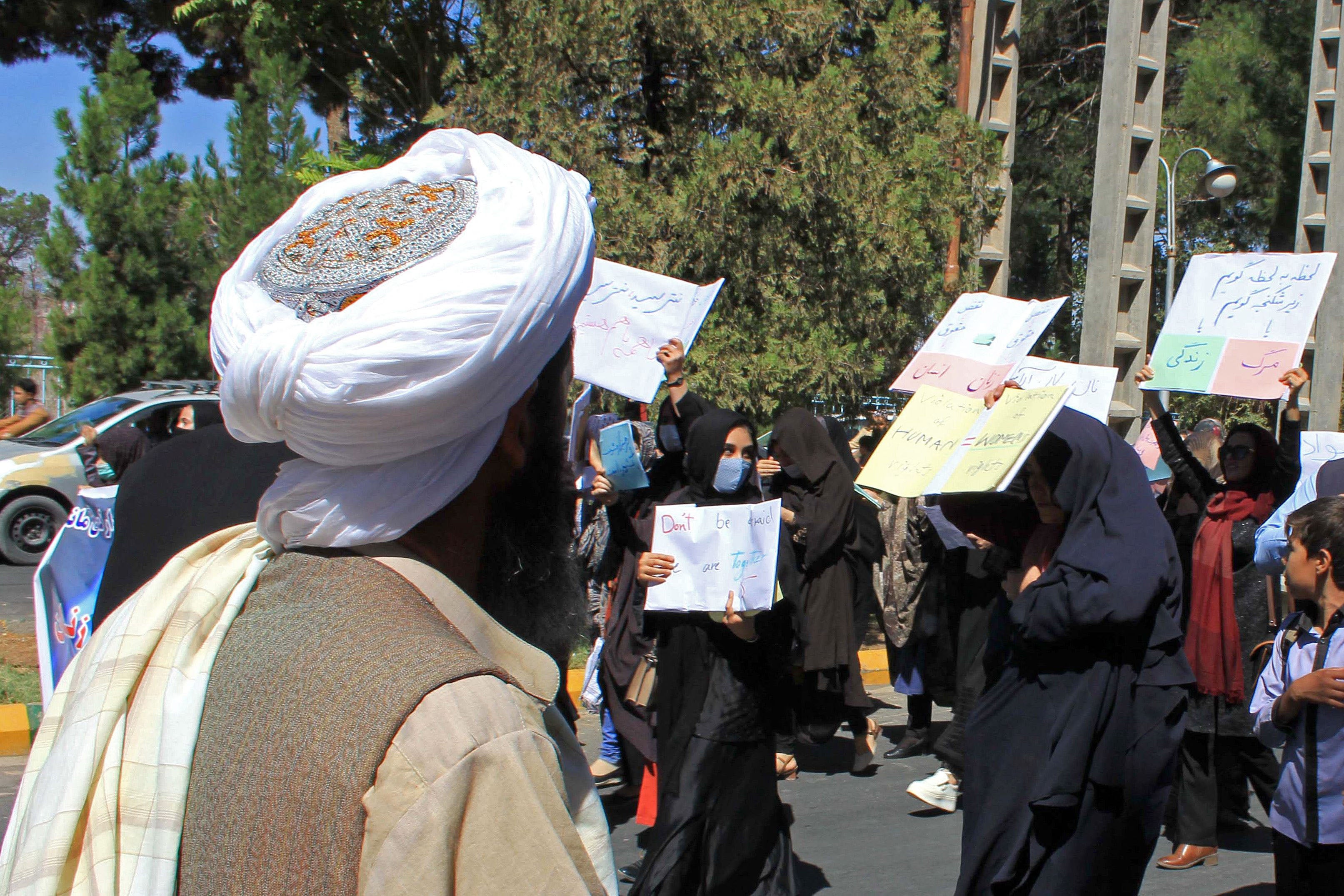 A Taliban member watches as women demonstrate for human rights in Herat, Afghanistan, September 2, 2021. 