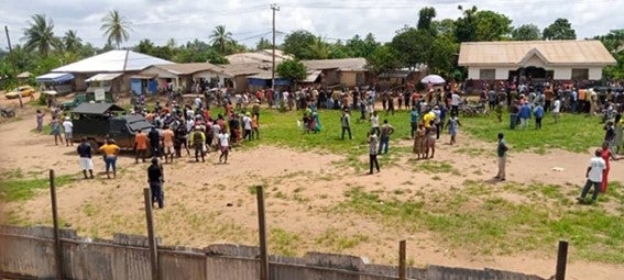 A rural schoolyard with people in it