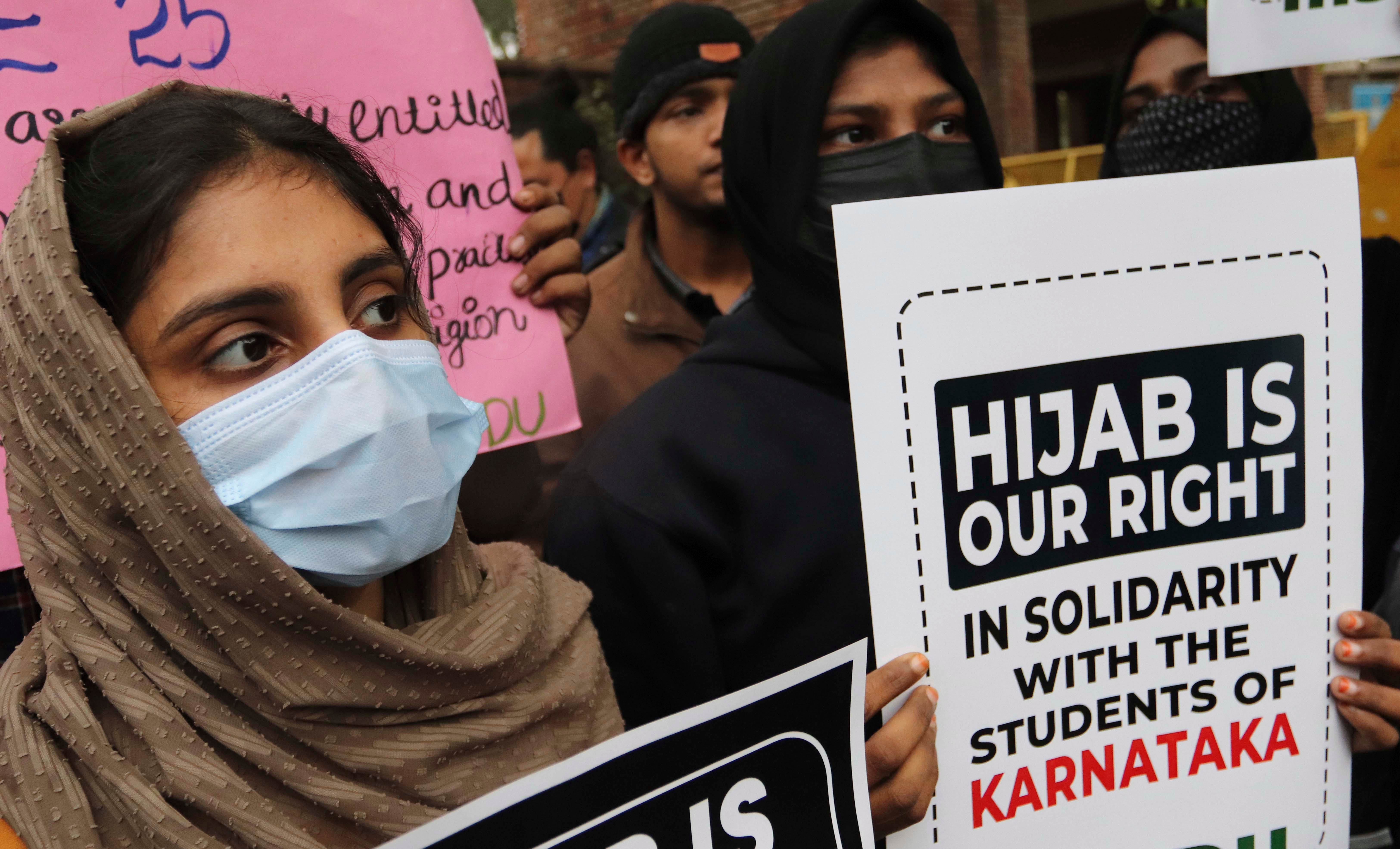 Women in masks holding up protest signs