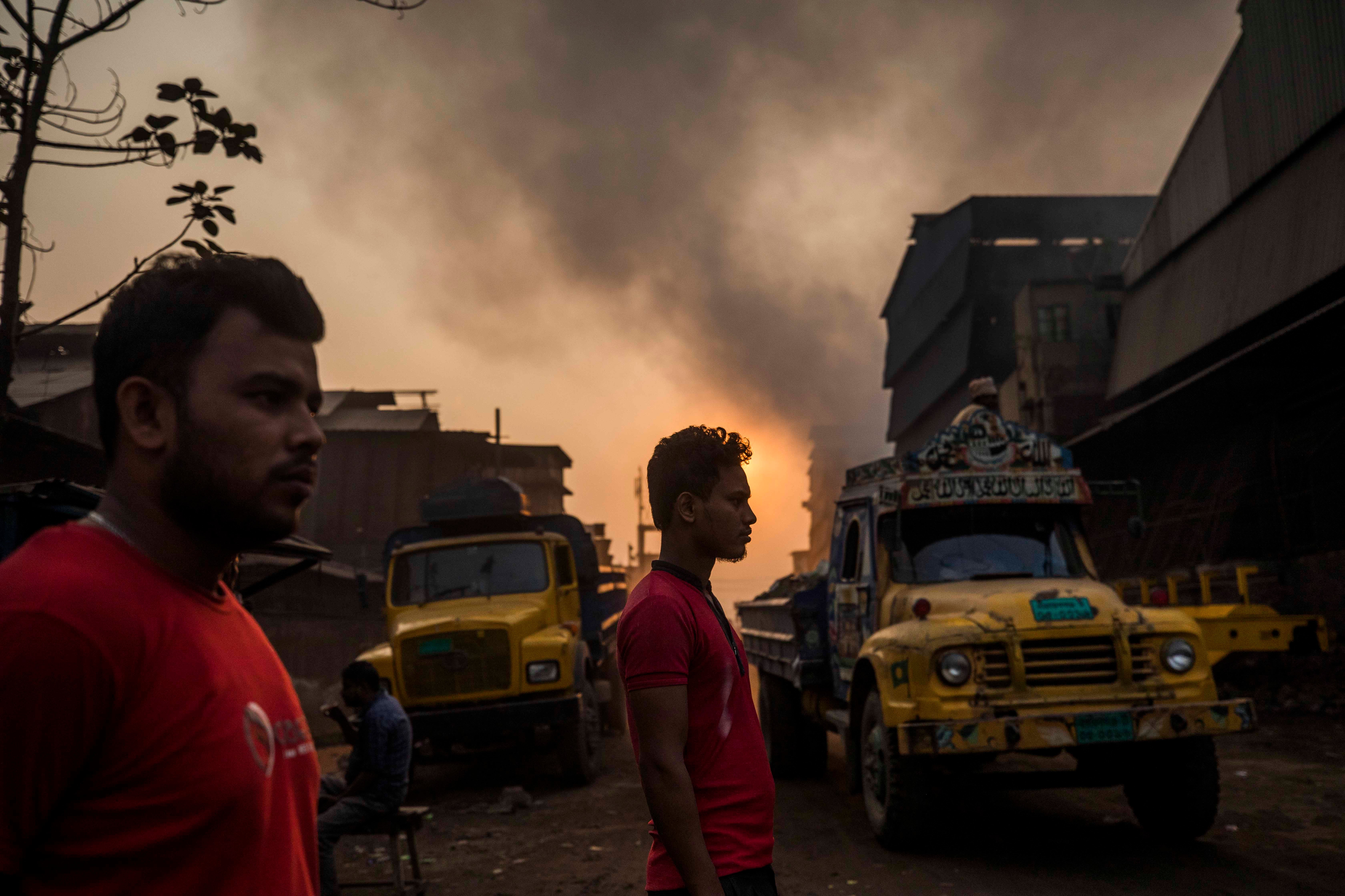 Two men stand in a smog-filled street
