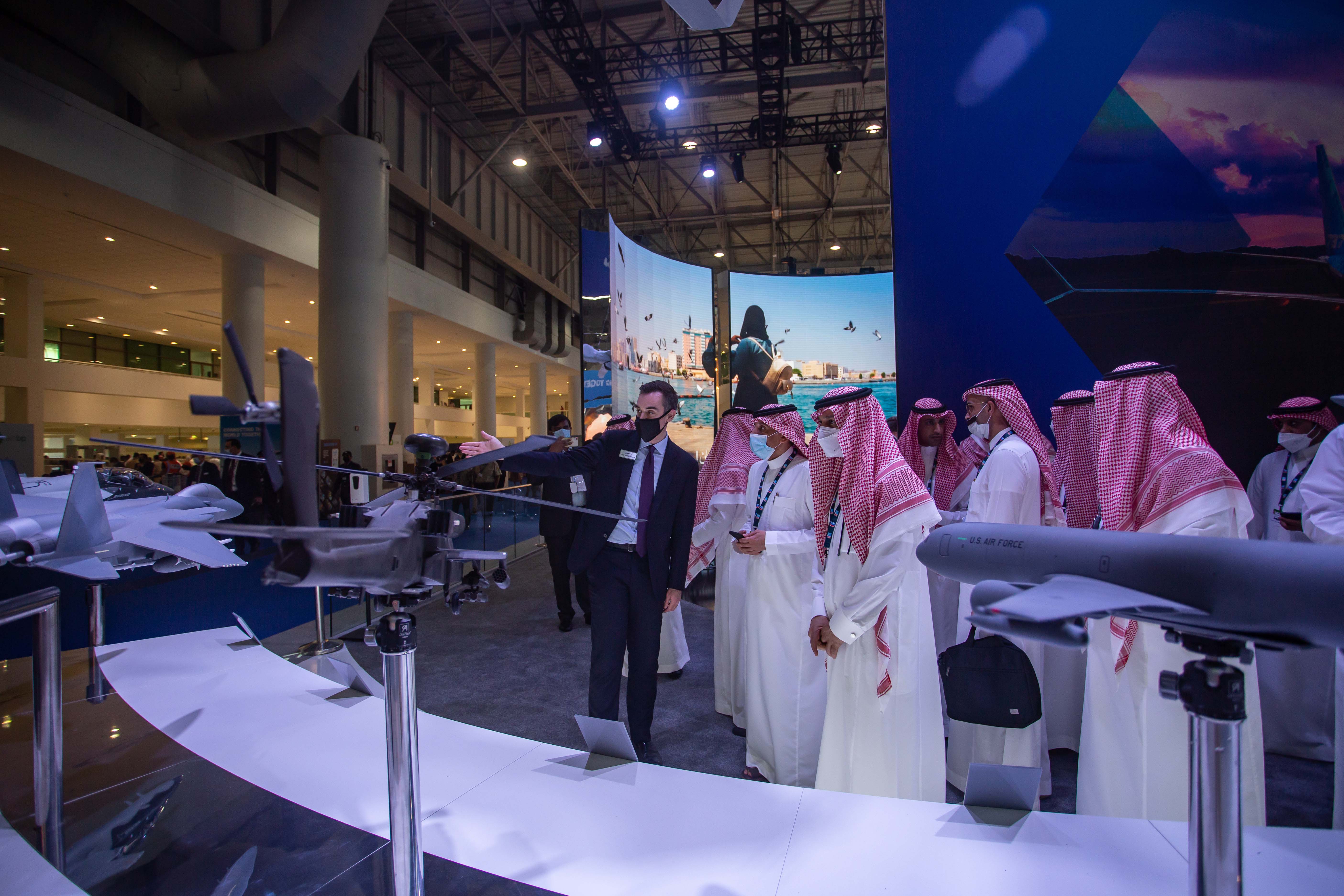 Men examine models of military equipment