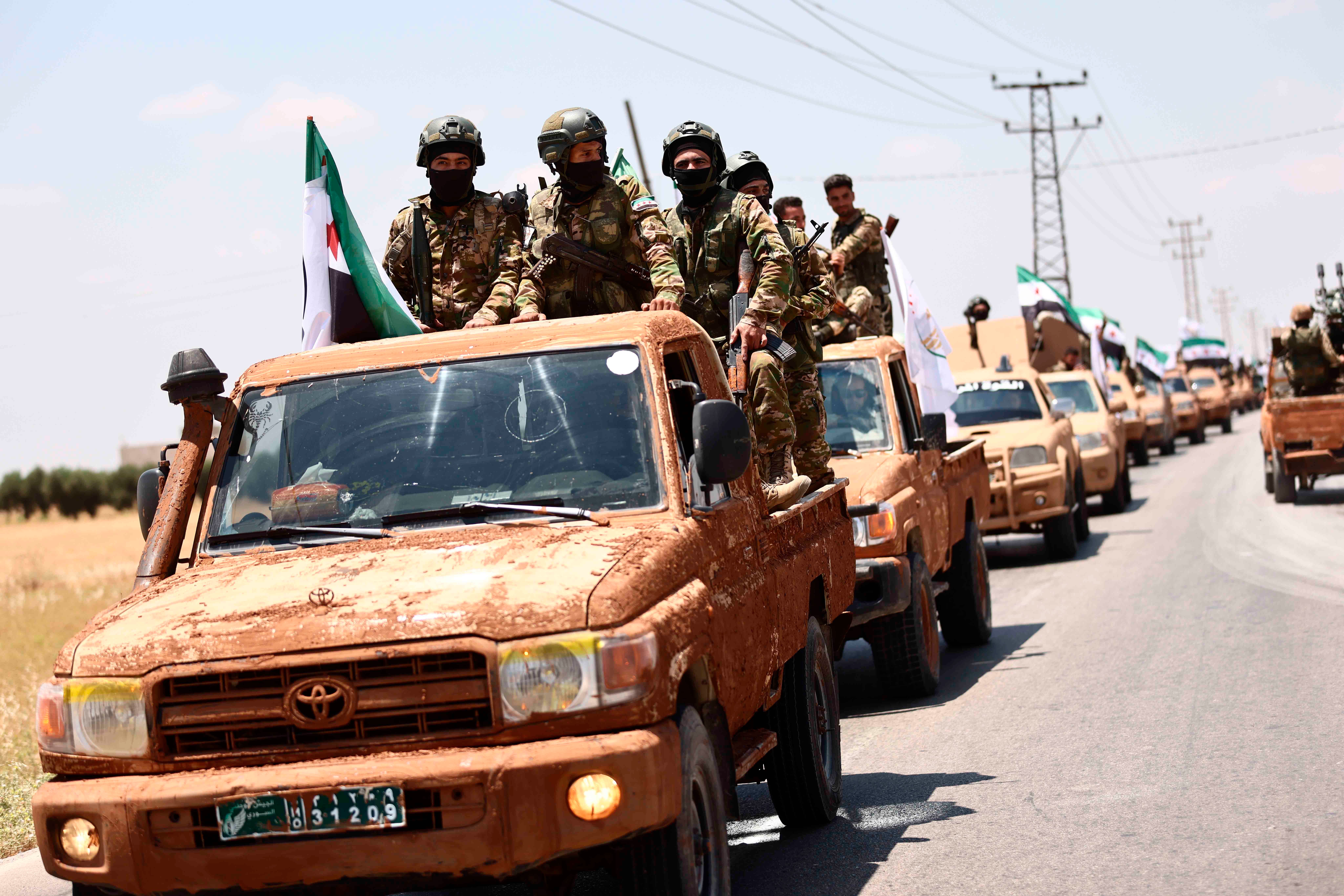 مقاتلون من "الجيش الوطني السوري" المدعوم من سوريا يشاركون في عرض عسكري في ريف محافظة حلب في 9 يونيو/حزيران 2022 كجزء من تحضيرات لعمل عسكري في المناطق التي تسيطر عليها "قوات سوريا الديمقراطية".