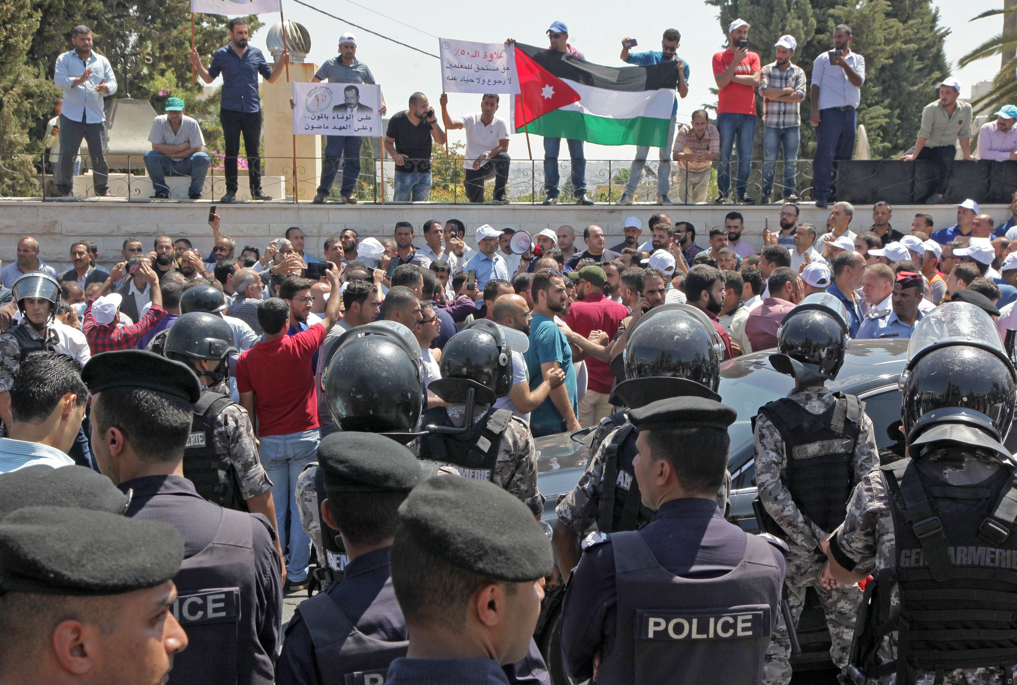 Jordanian teachers display their national flag during a protest in the capital of Amman on September 5, 2019.