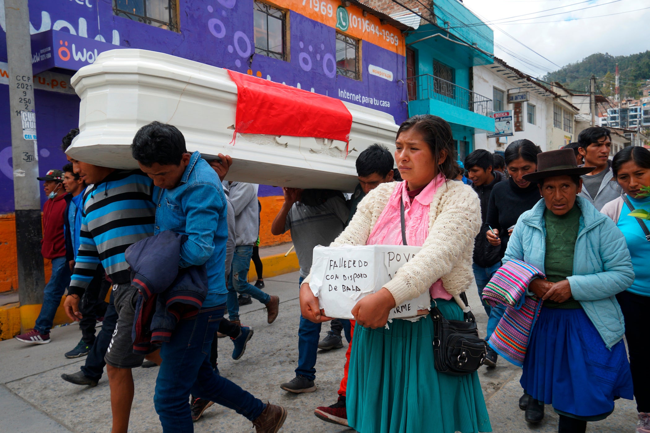 The relatives of 18-year-old Wilfredo Lizarme walk around the city streets with the casket that contains his body, in Andahuaylas, Peru.