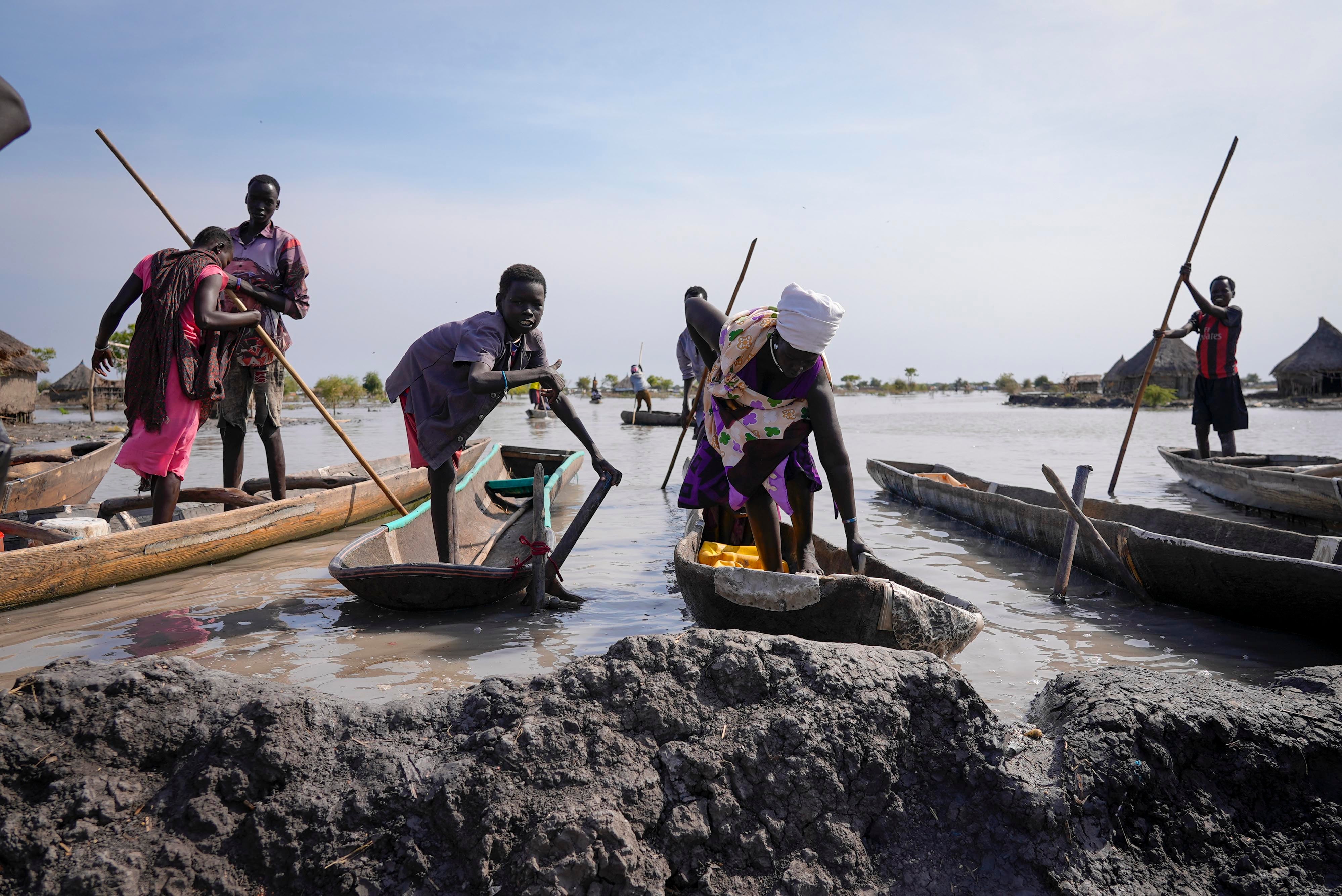 Residents park their dugout canoes next to a mud dyke they built to try and prevent flooding