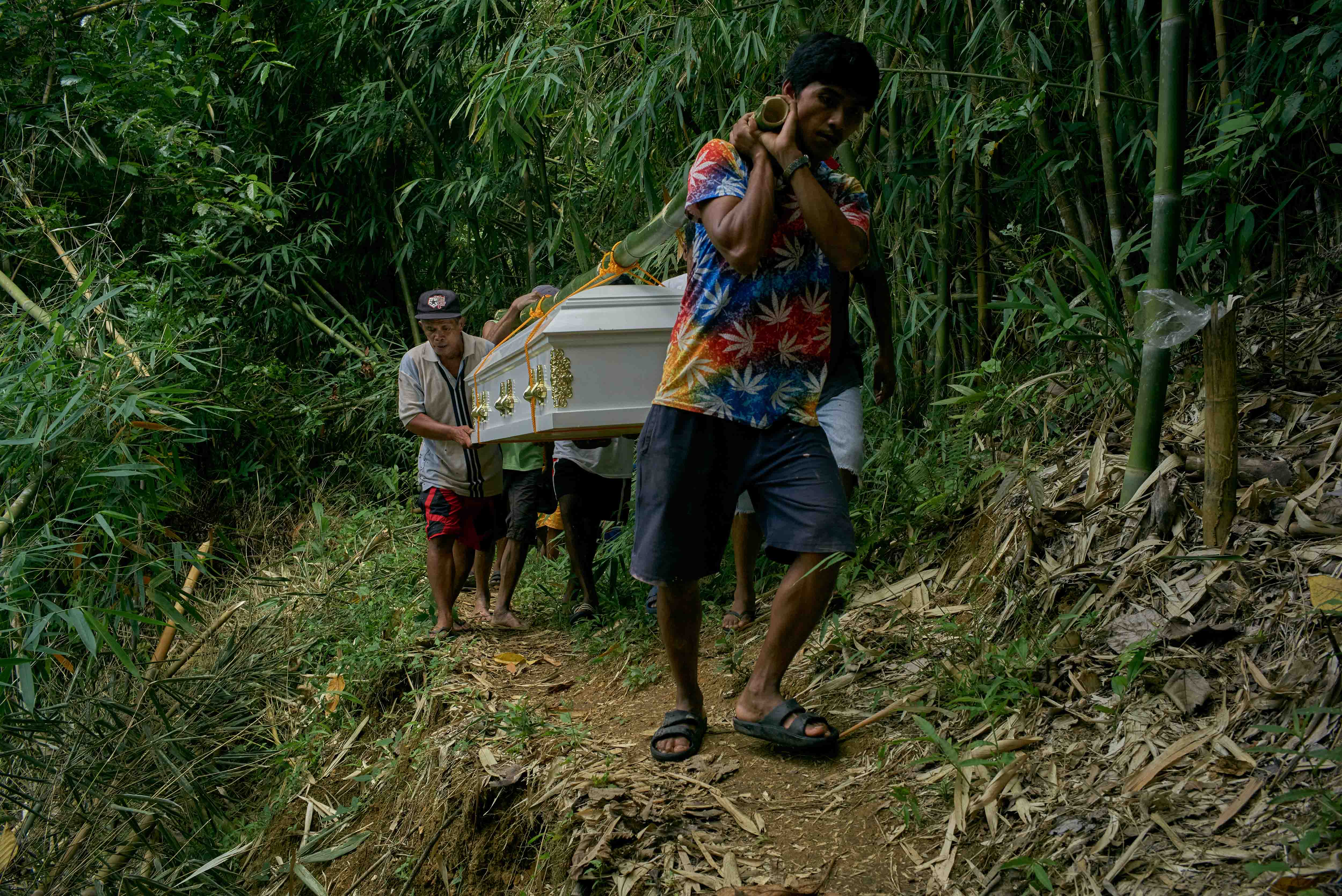 Family and members of the Indigenous Dumagat tribe carry the coffins of Puroy and Randy Dela Cruz to be buried in Rizal province
