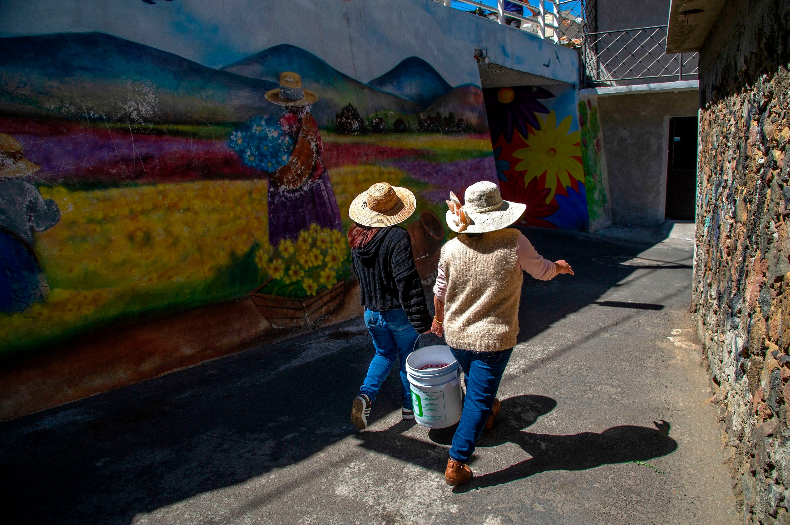 Members of the collective Mujeres de la Tierra, walk with corn to a neighborhood mill, in Milpa Alta, Mexico City, on February 16, 2021. The collective Mujeres de la Tierra started in May, 2020, as a way to help survivors of domestic violence generate an income amid the COVID-19 pandemic.