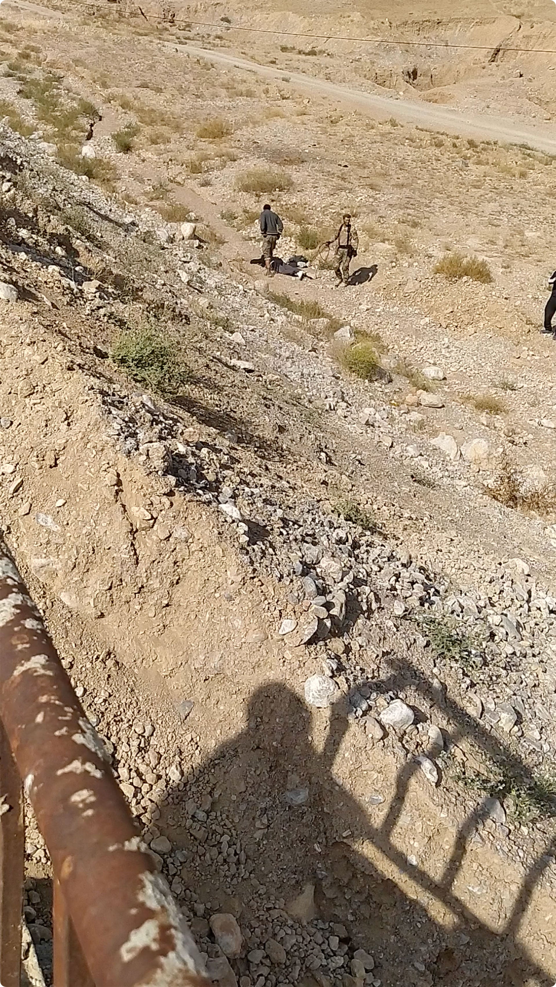 Kyrgyz soldiers inspect the body of 22-year-old Myktybek Avrorov, killed by Tajik forces while fleeing the Kyrgyz village of Ak-Sai on September 16, 2022.