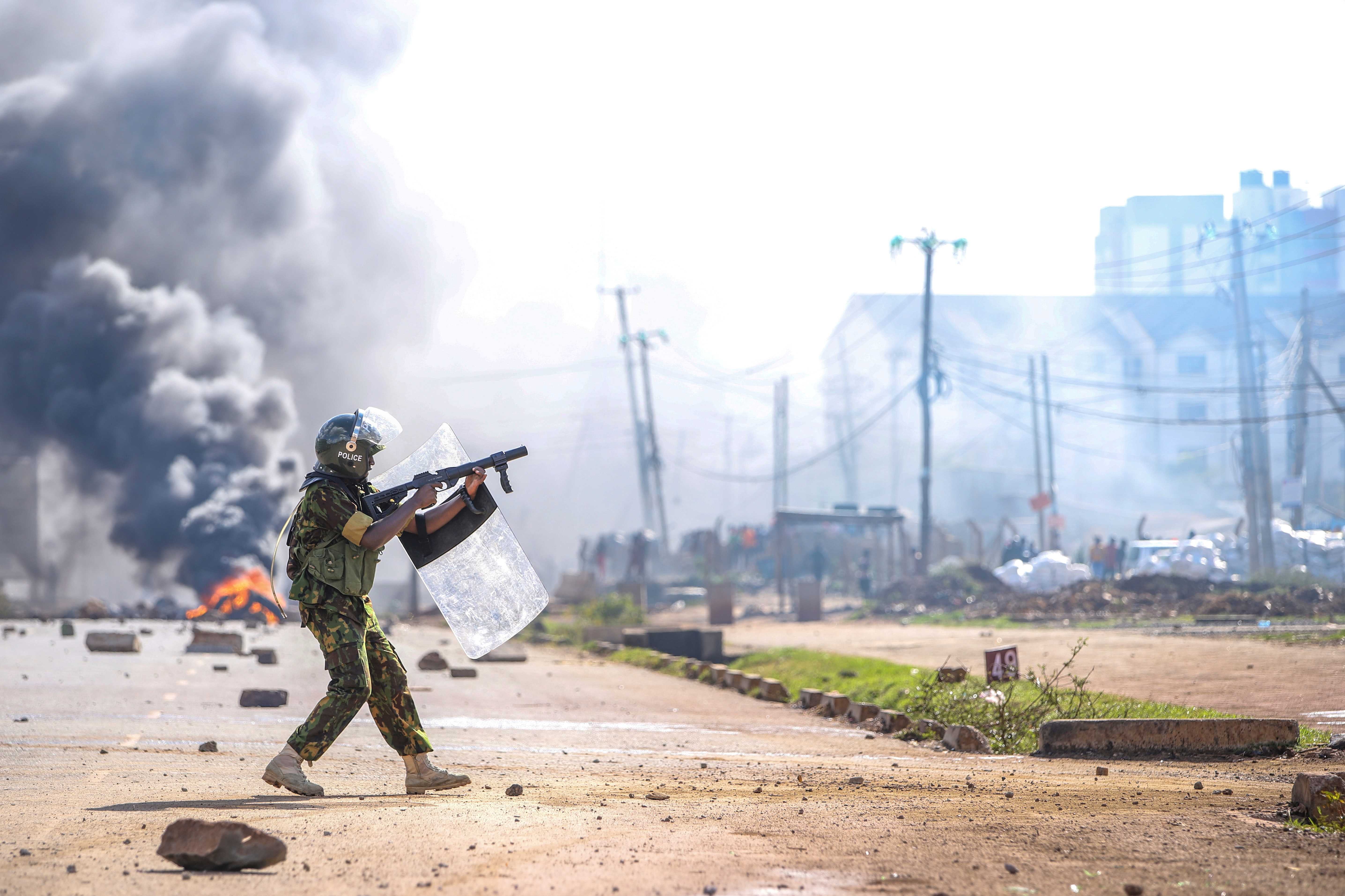 A riot police officer fires tear gas at protesters during a mass rally called by the opposition leader Raila Odinga over the high cost of living, in Nairobi, Monday, March 27, 2023. 