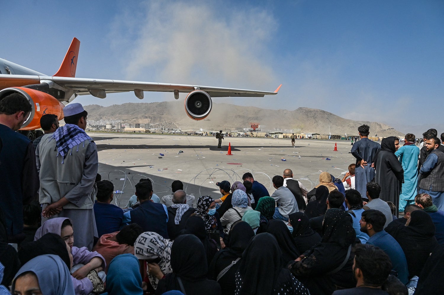 Des Afghans attendant de quitter l'Afghanistan à l'aéroport international de Kaboul après la prise de pouvoir des talibans, 16 août 2021.