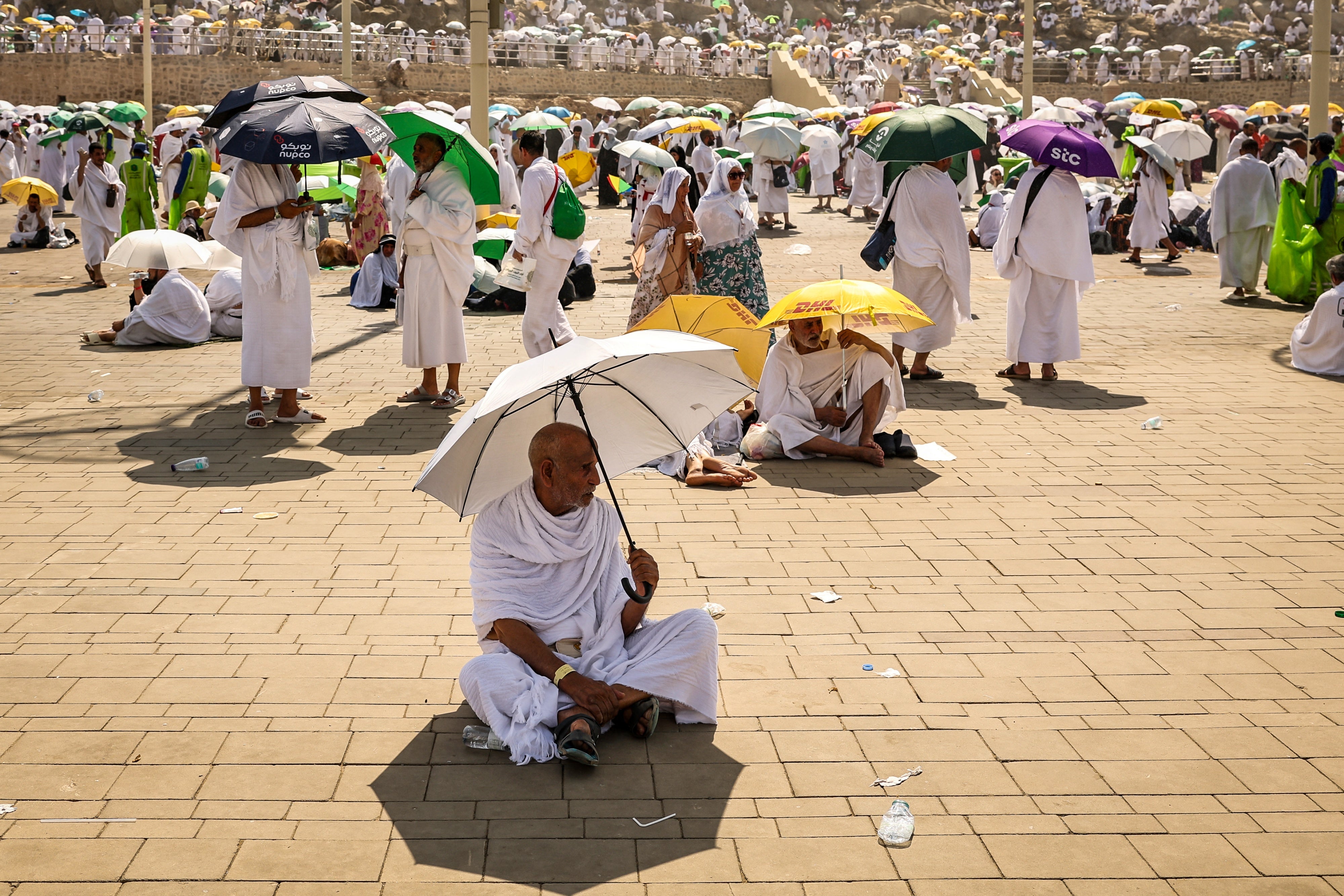 Pilgrims use umbrellas to shade themselves from the sun as they arrive at the base of Mount Arafat, also known as Jabal al-Rahma or Mount of Mercy, during the annual hajj pilgrimage on June 15, 2024. 