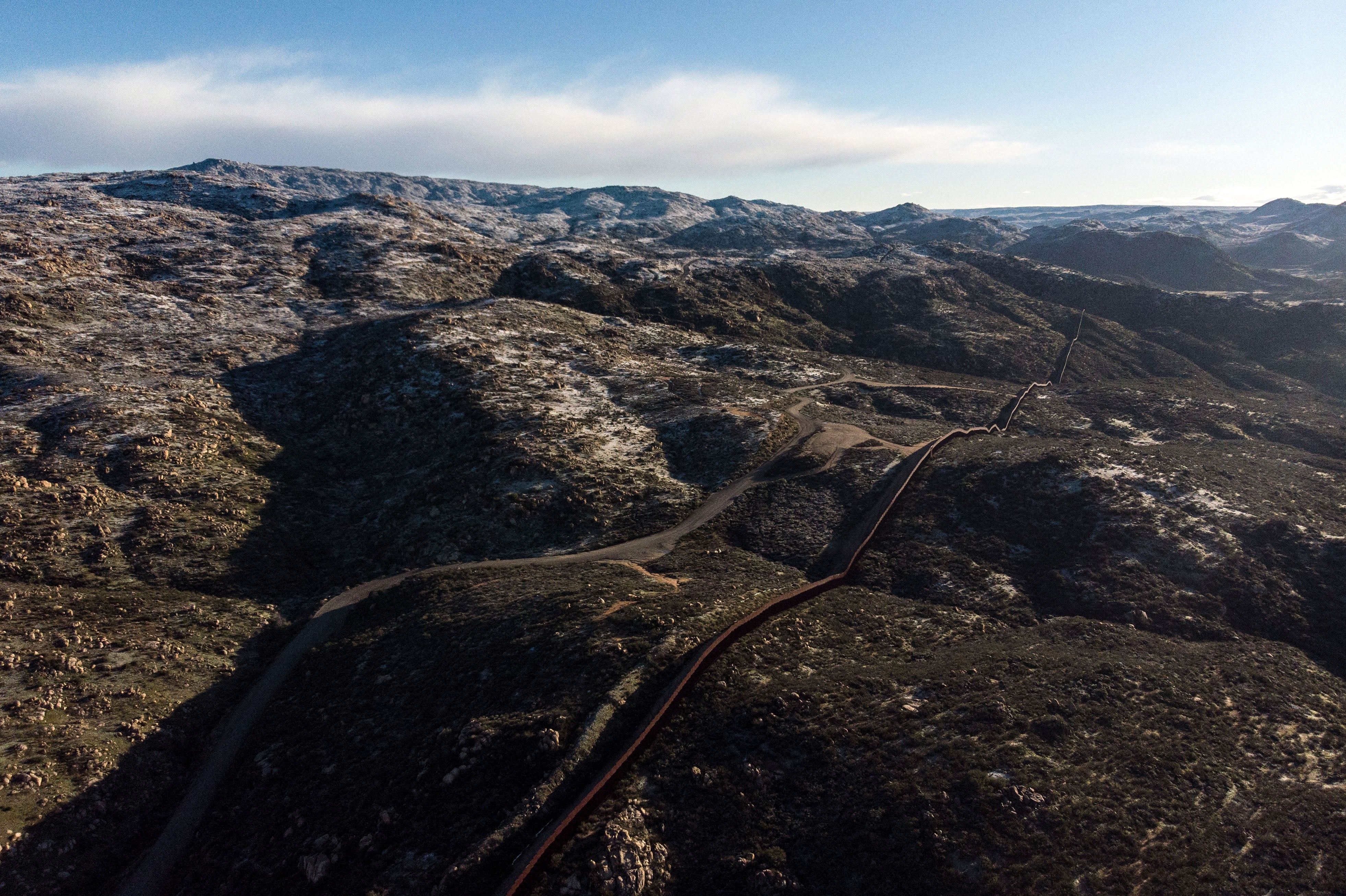 Aerial view of the US-Mexico border fence in the outskirts of Tecate, Baja California state, Mexico, on February 22, 2019. 