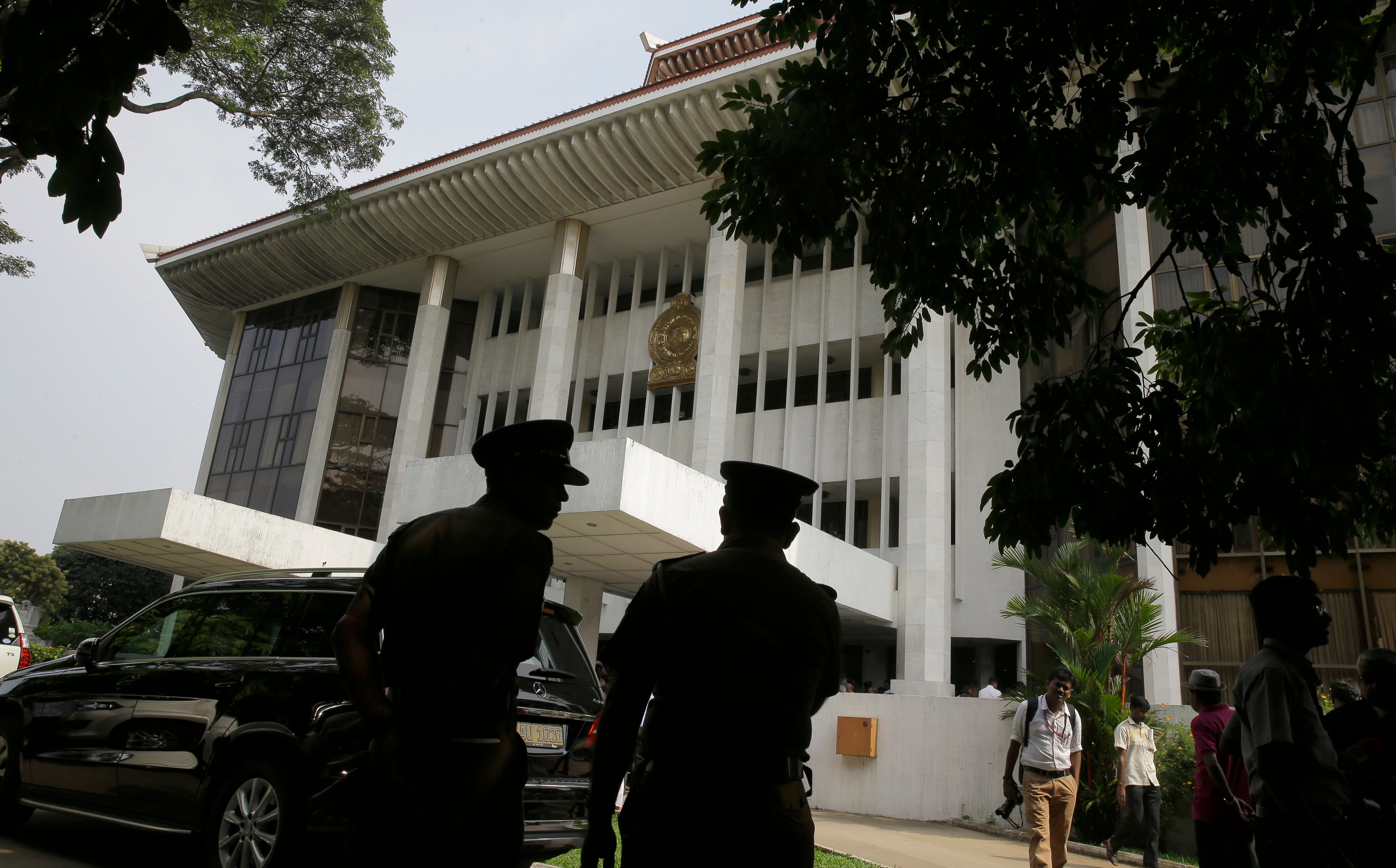 Police officers stand in front of a building.