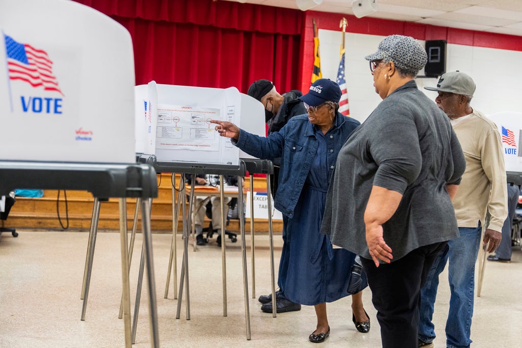 Election workers help voters on the state's primary election day at Lewisdale Elementary School in Chillum, Maryland, May 14, 2024.