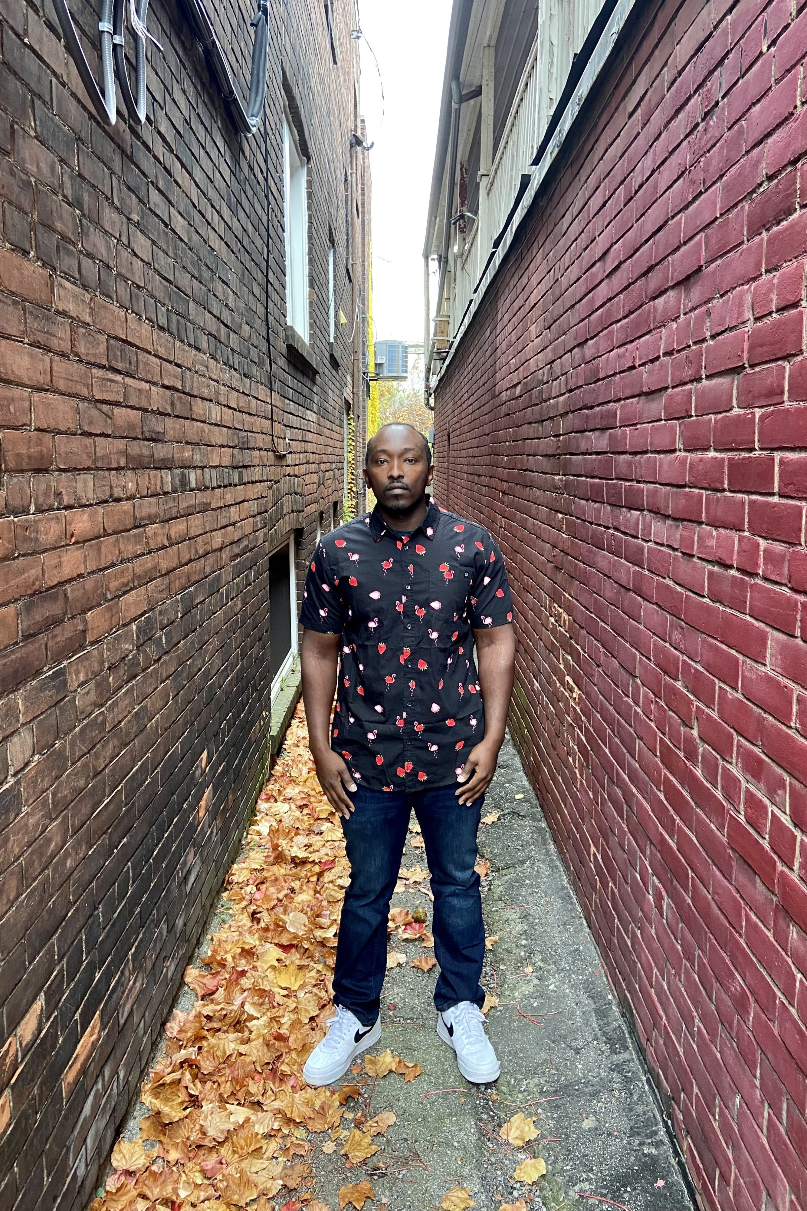 A man standing in an alleyway. 