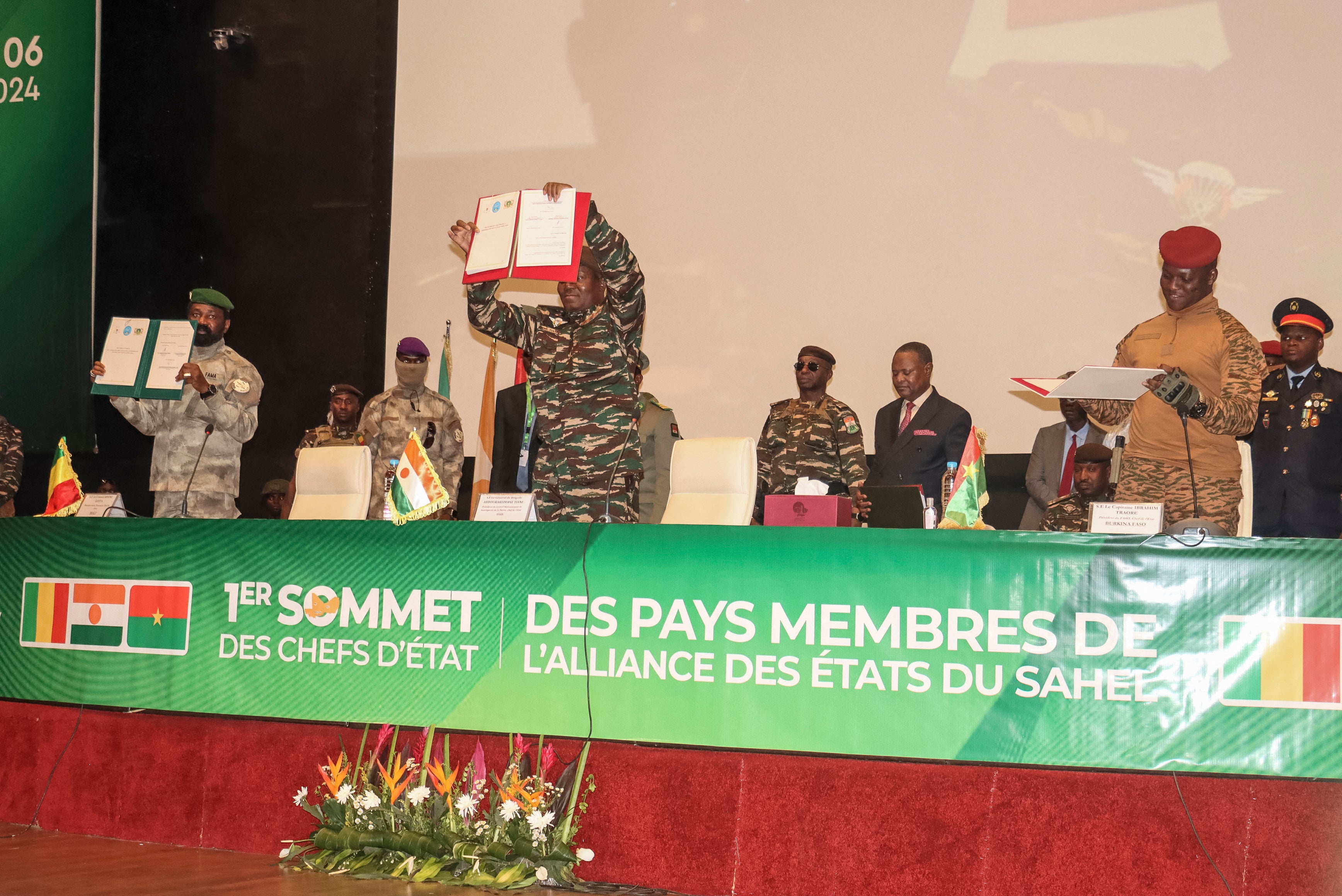 The leaders of Niger, Gen. Abdourahamane Tiani (C), Mali, Col. Assimi Goita (L), and Burkina Faso, Capt. Ibrahim Traore (R), show the documents of the Confederation of Sahel States, which they signed during their first summit in Niamey, Niger, July 6, 2024.