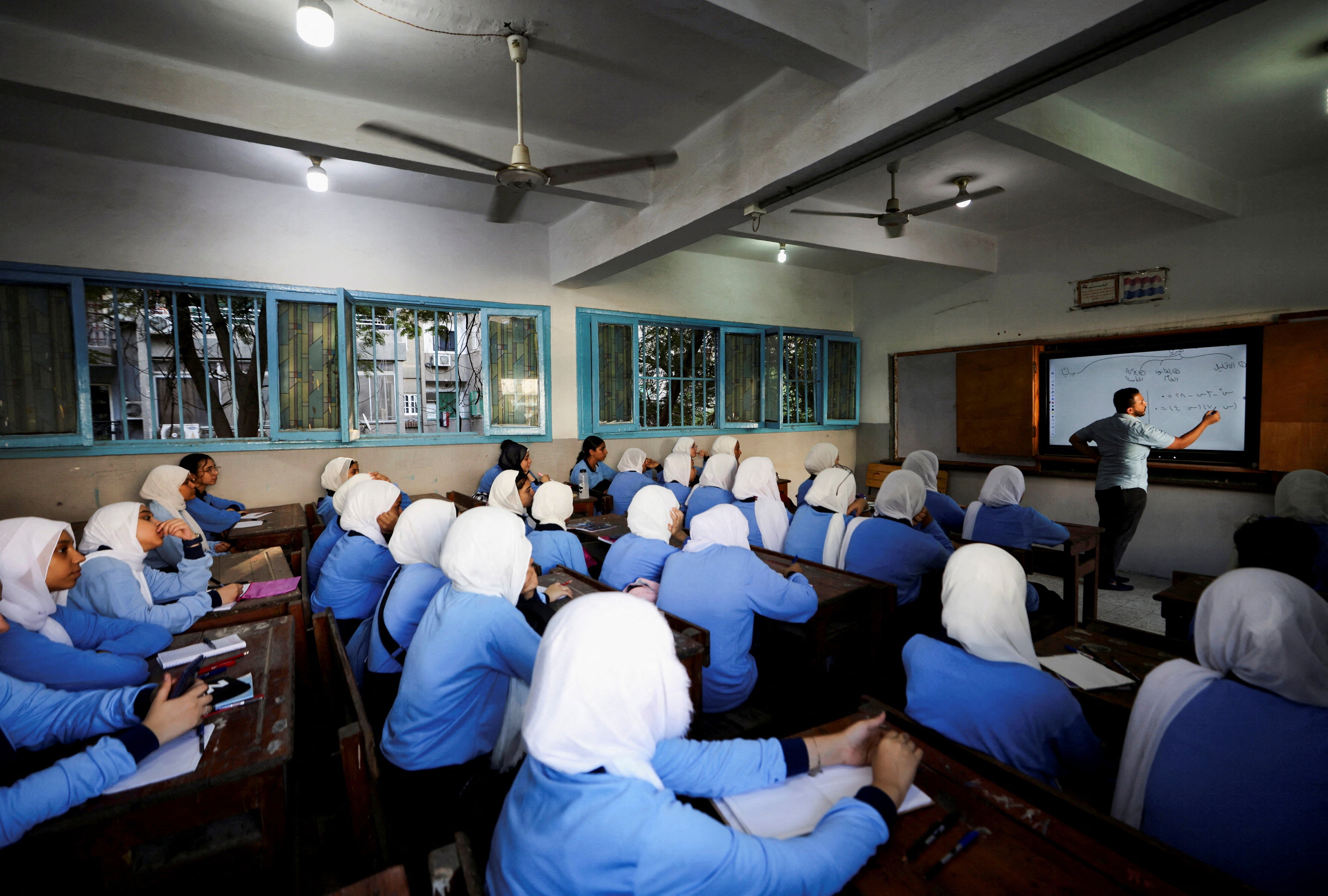 An Egyptian teacher instructs students on the first day of the academic year at Orman school, in Cairo, Egypt, September 22, 2024. 