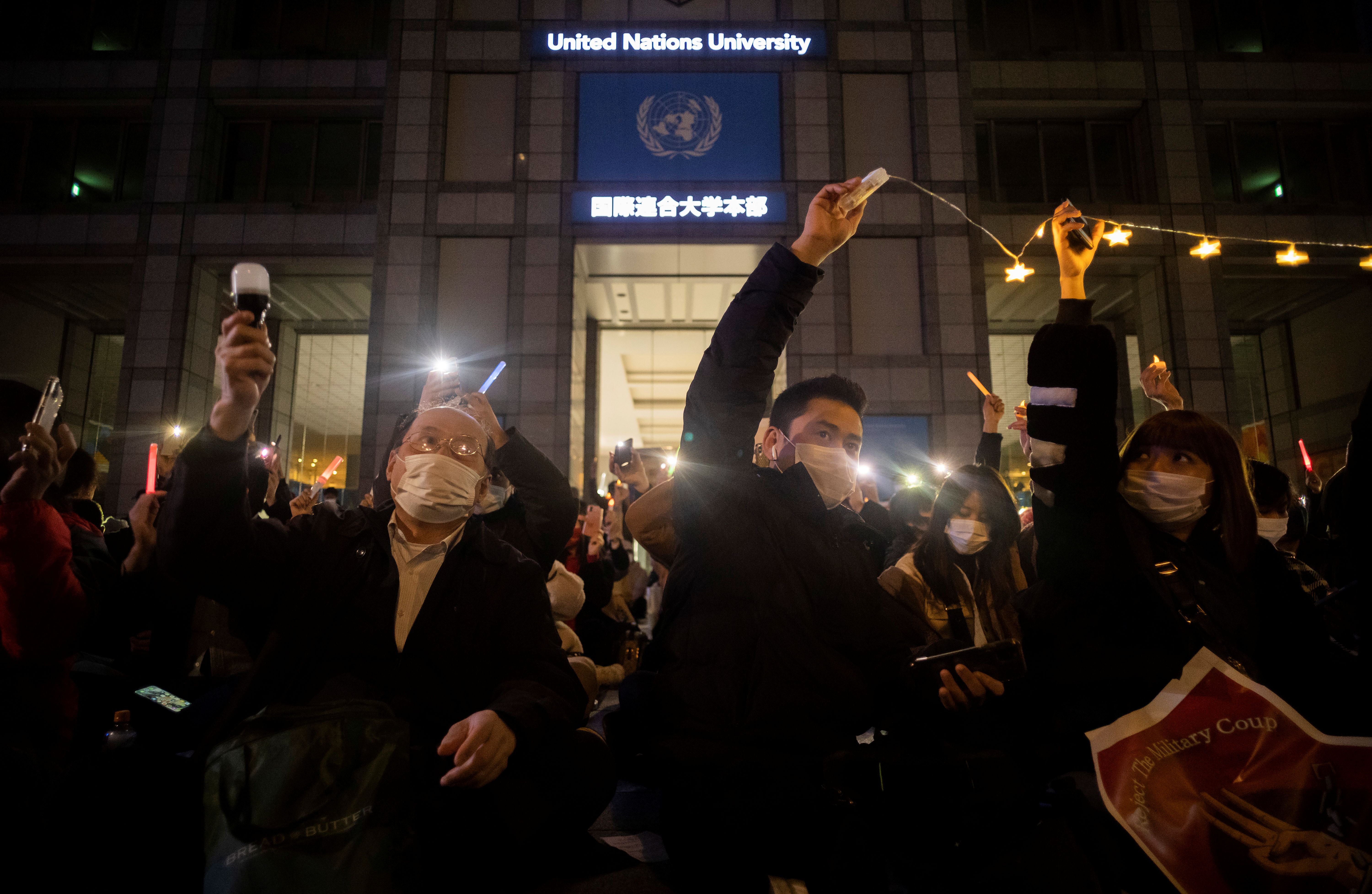 People protest outside a university building at night