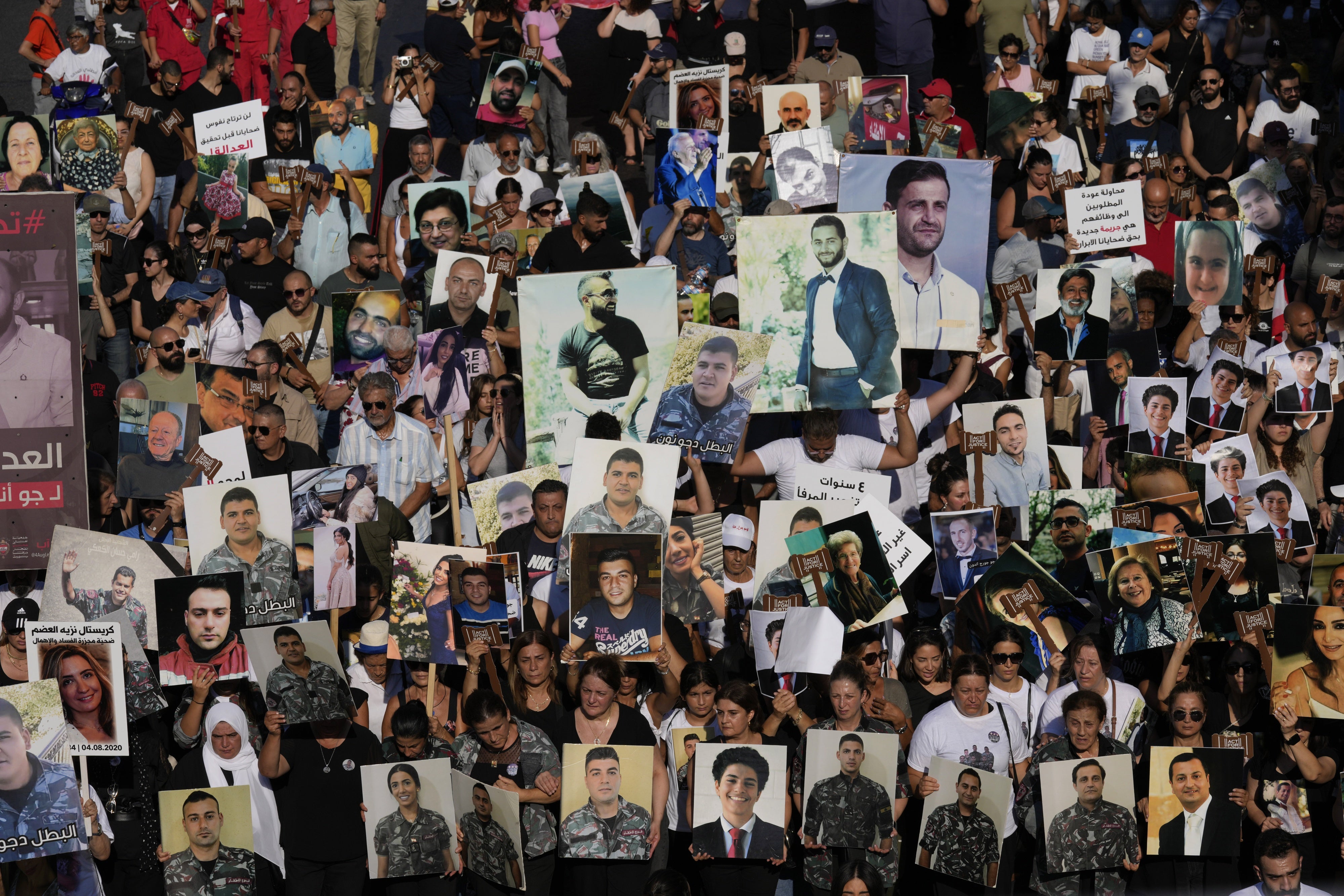 Relatives of the victims of the deadly 2020 Beirut blast hold portraits of their loved ones on the fourth anniversary of the blast, August 4, 2024.