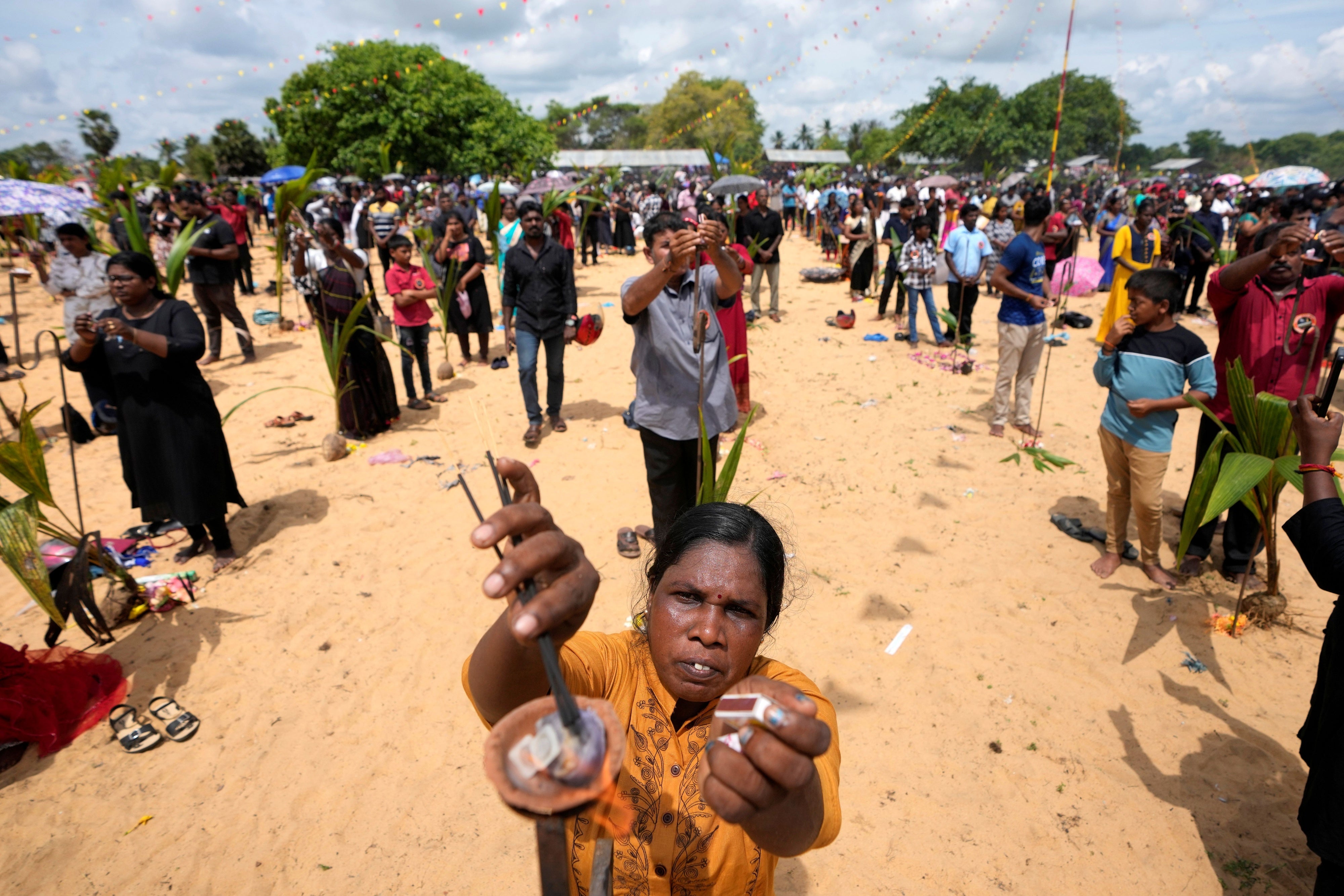 People perform rituals in memory of their deceased or missing relatives on a beach