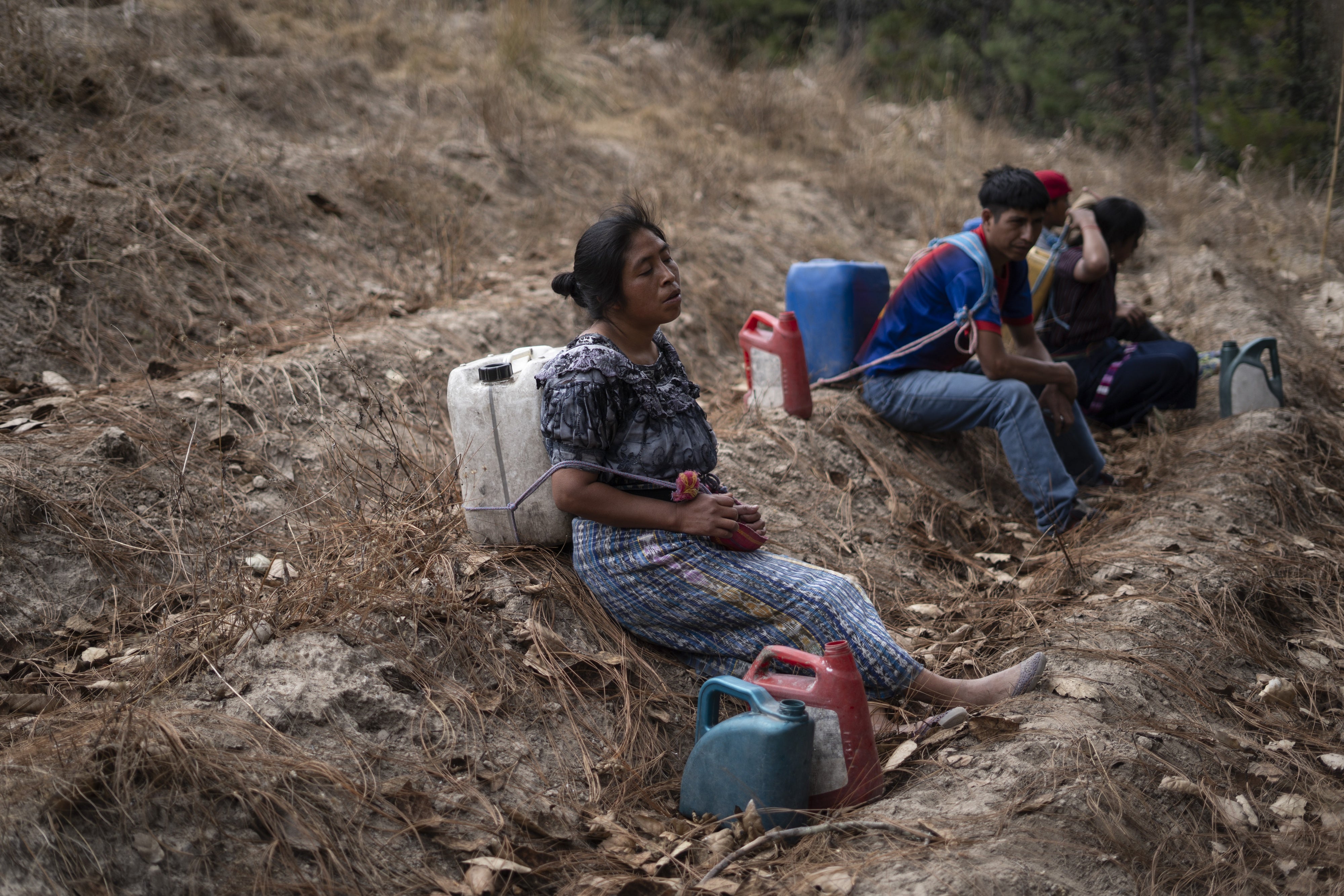 A family stops to rest while transporting water from a well in Santa María Chiquimula municipality, Totonicapán department. 