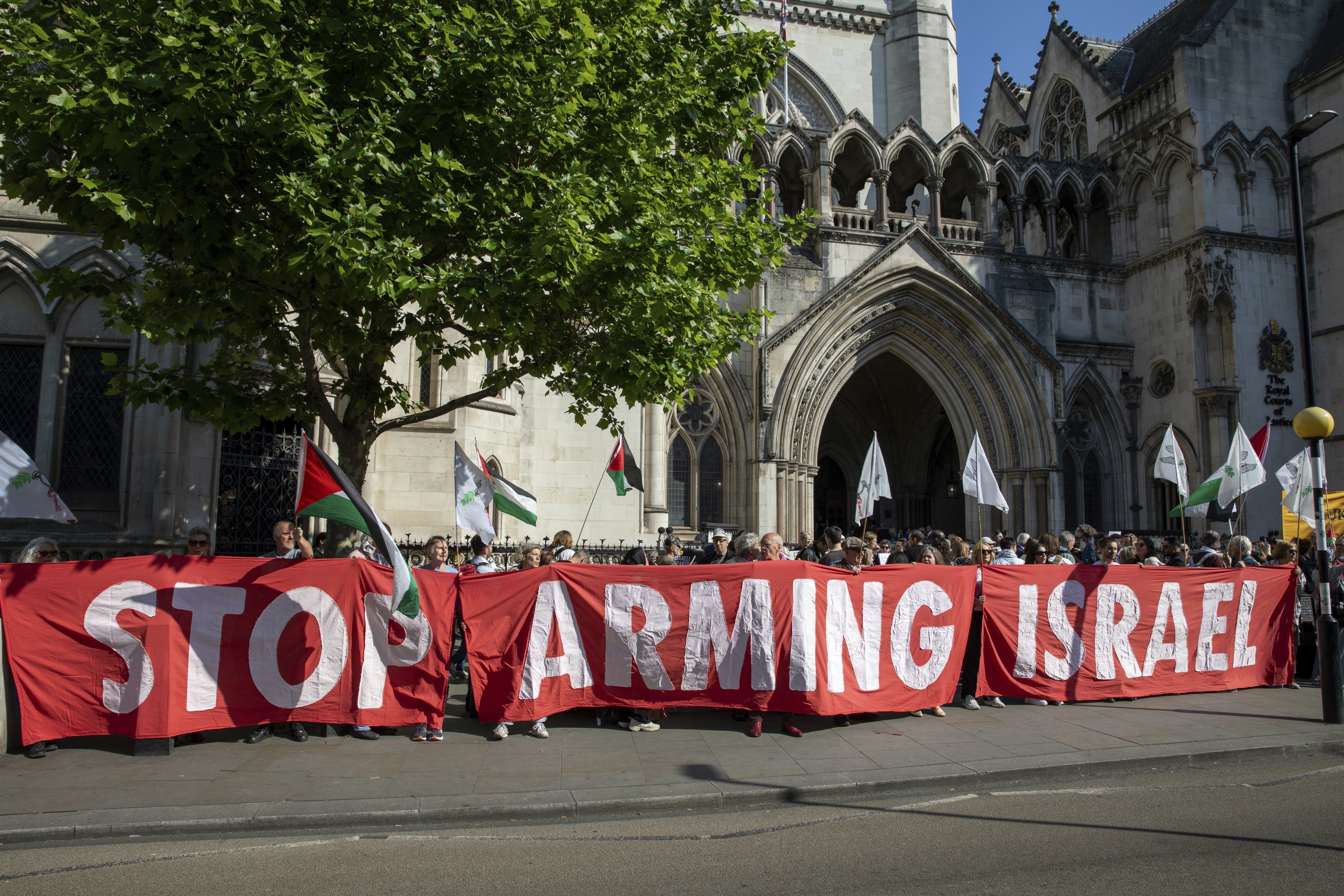 Bei einer Demonstration vor dem Royal Courts of Justice in London, Großbritannien, halten Aktivist*innen am 13. Mai 2025 ein Transparent hoch.