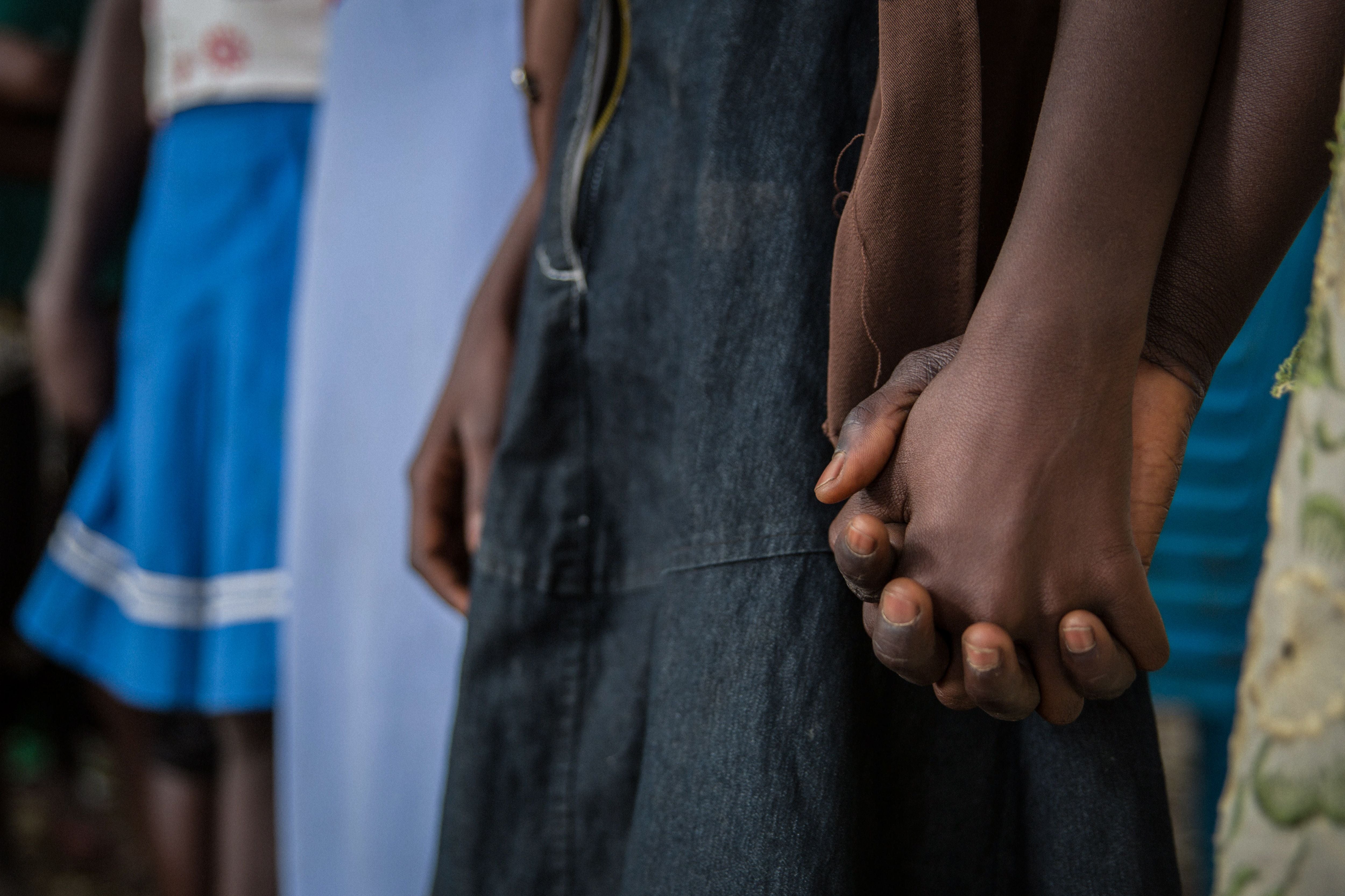 Girls who had been abducted by armed groups and forced to cook in captivity during conflict in Yambio, South Sudan, hold hands during a ceremony marking their release from captivity on February 7, 2018. 