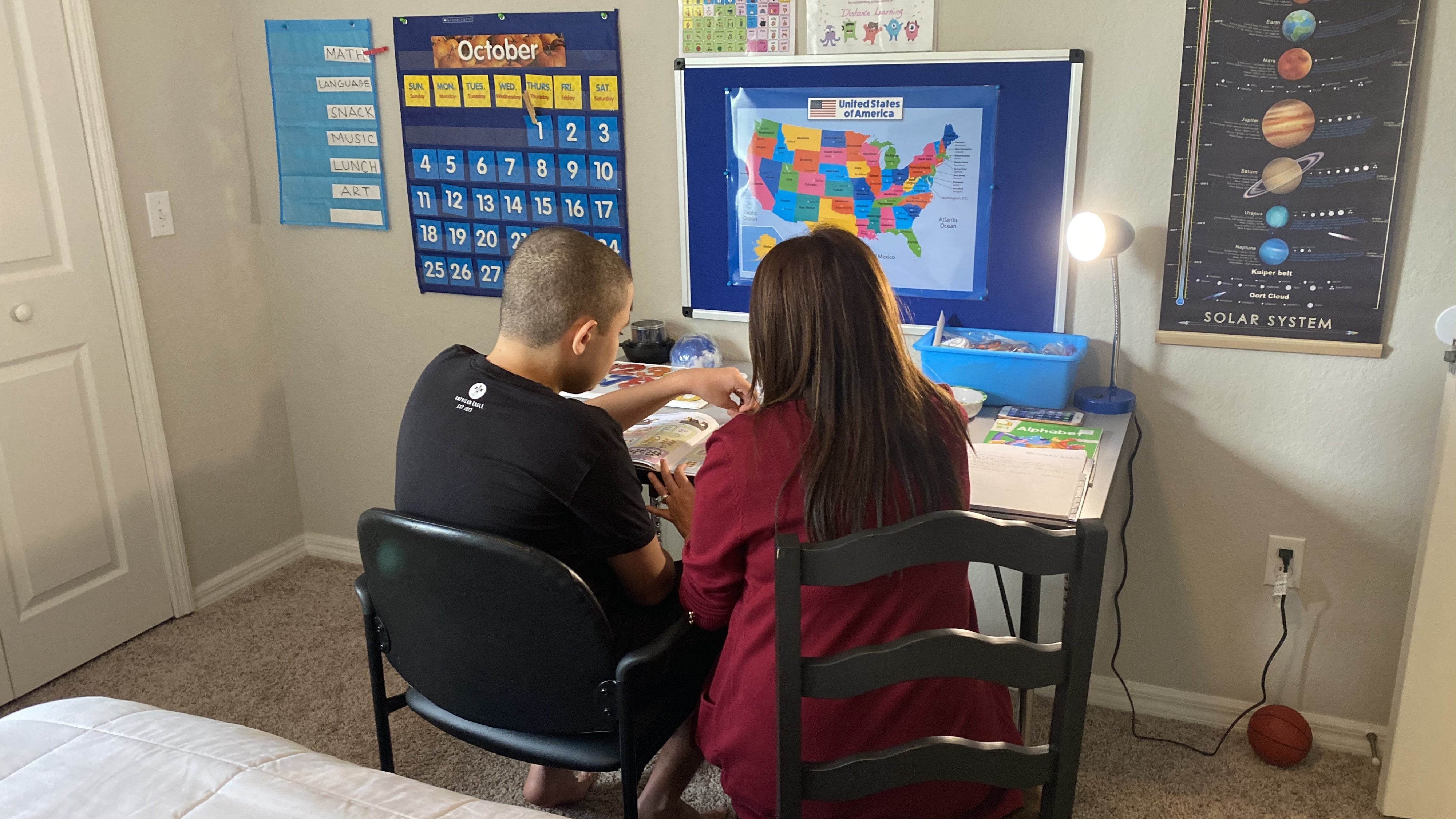 A mother supporting her 14-year-old son with autism in homeschooling, Orlando, Florida, US, October 1, 2020.