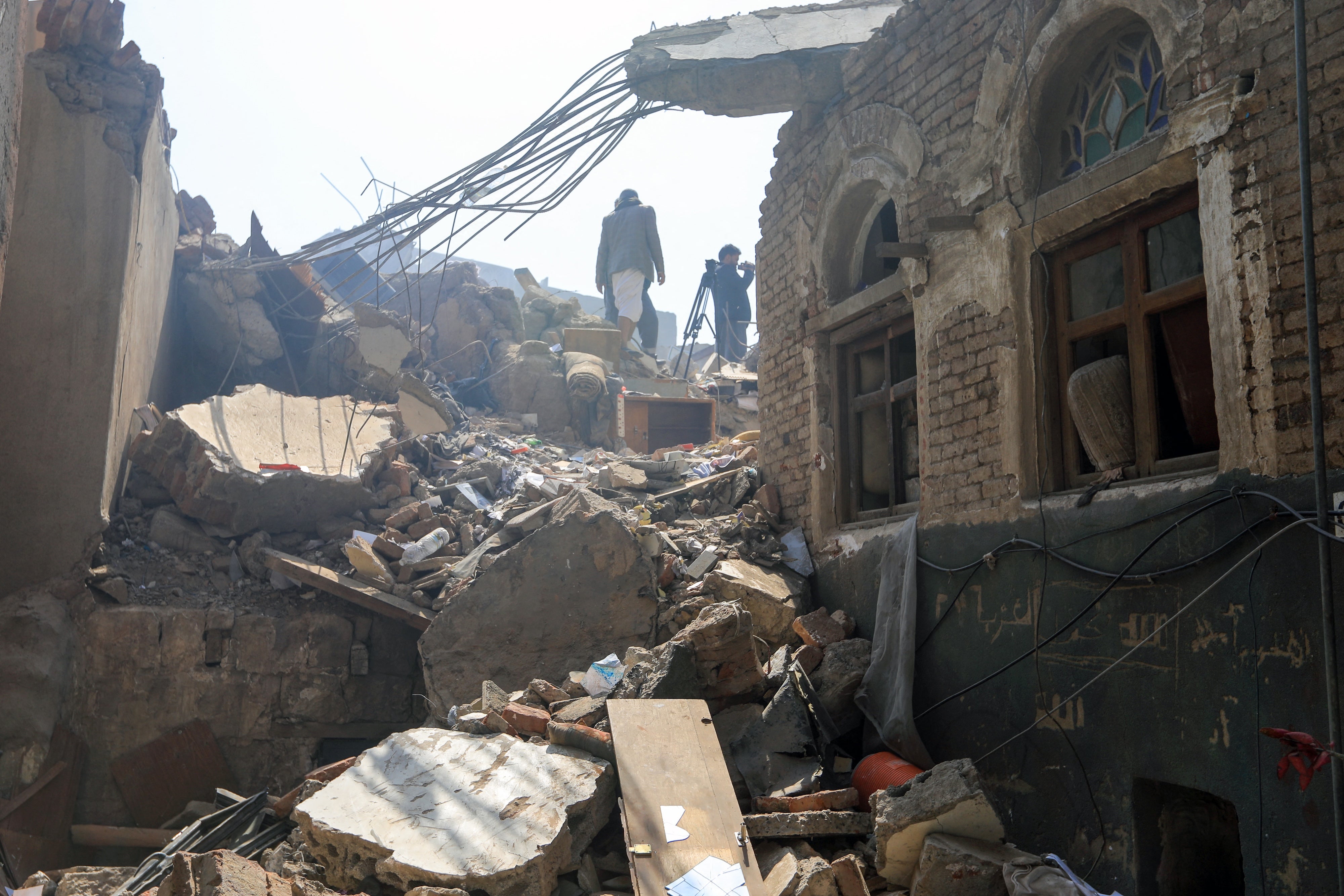 People inspect damage on September 13, 2025, in Sanaa, Yemen days after an Israeli strike hit the center of the city.