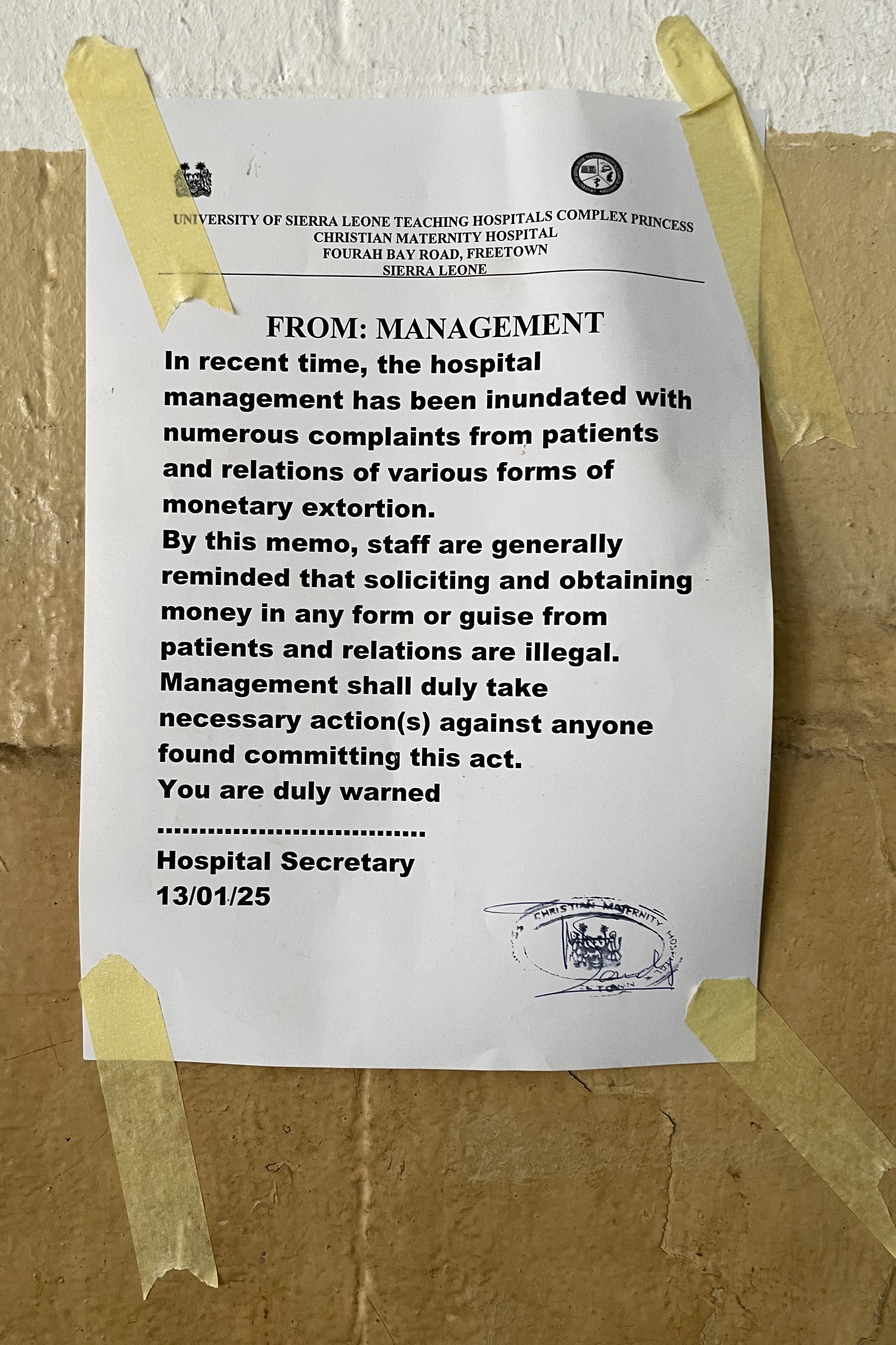 A poster taped to a wall about extortion at a hospital