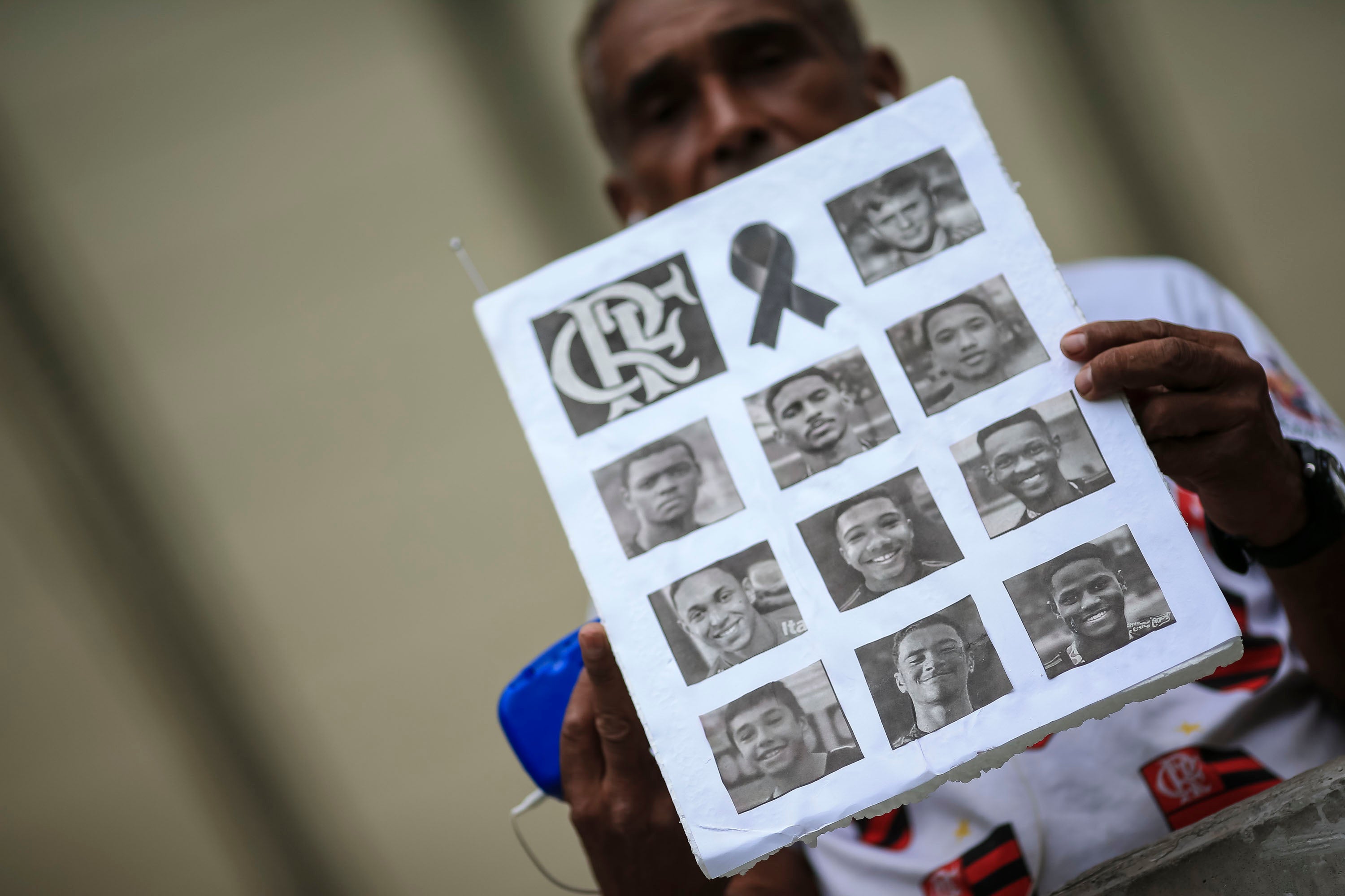 A fan shows photos of athletes of died