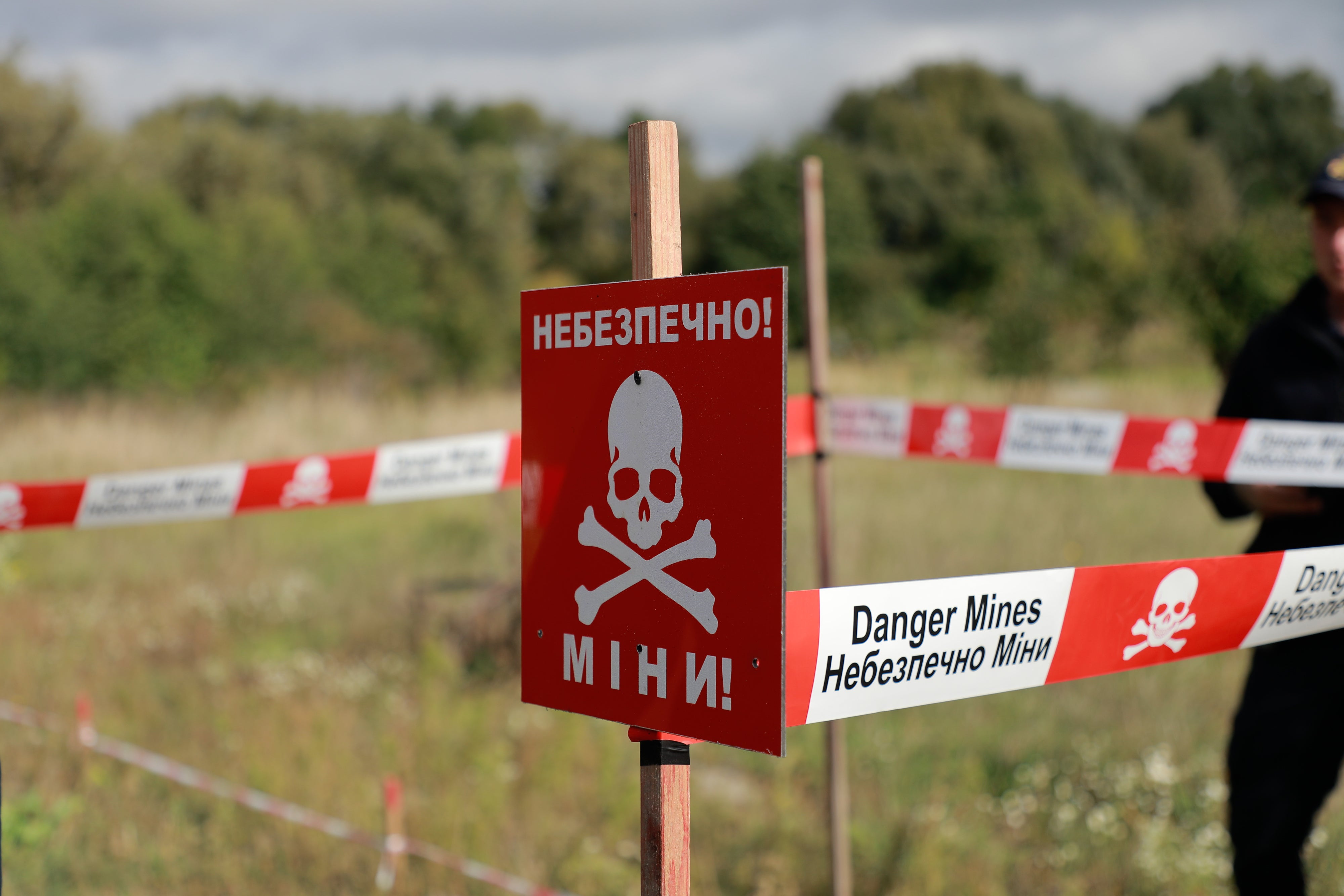Sign reading "danger mines" in English and Ukrainian.