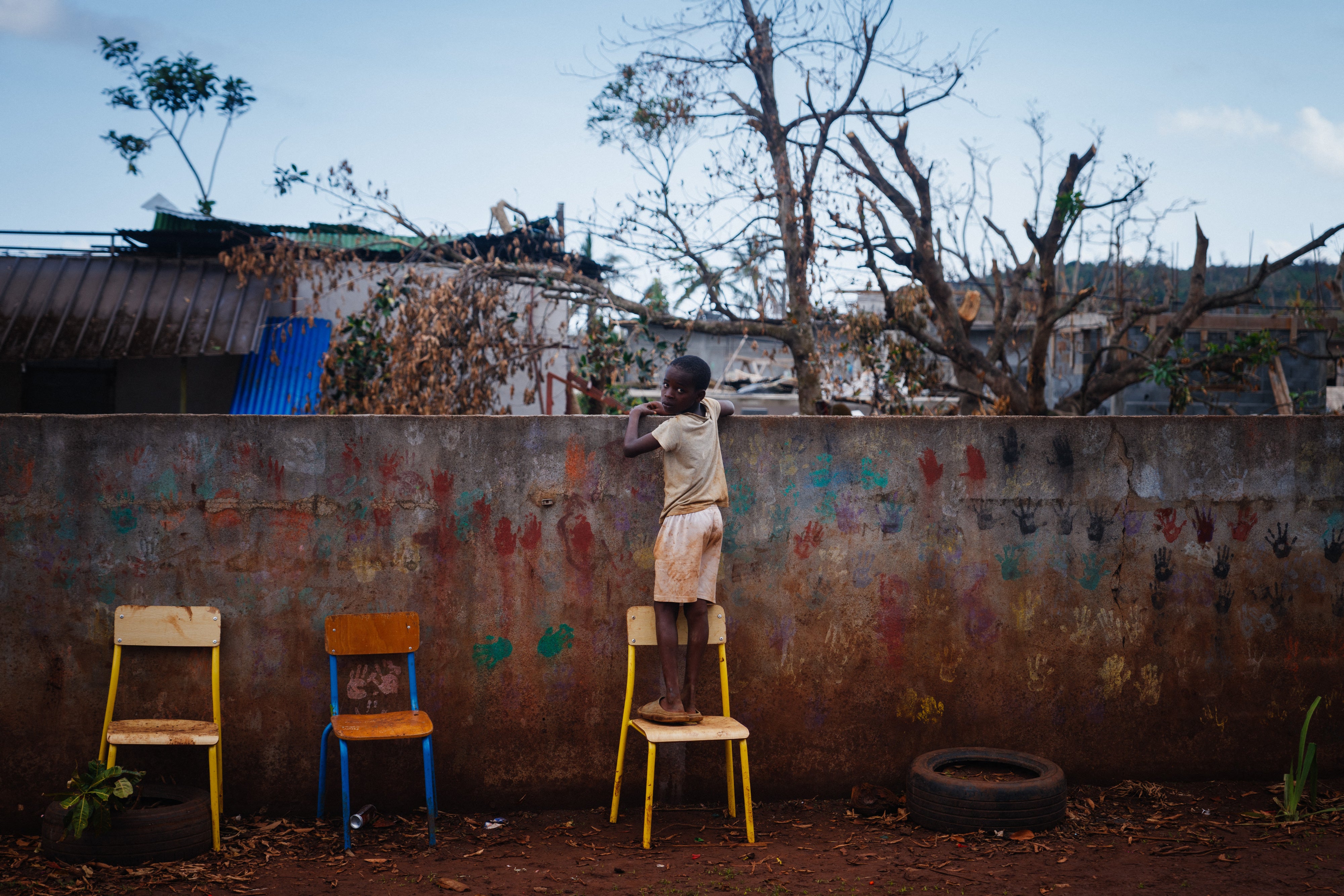 A boy looks over a school fence 