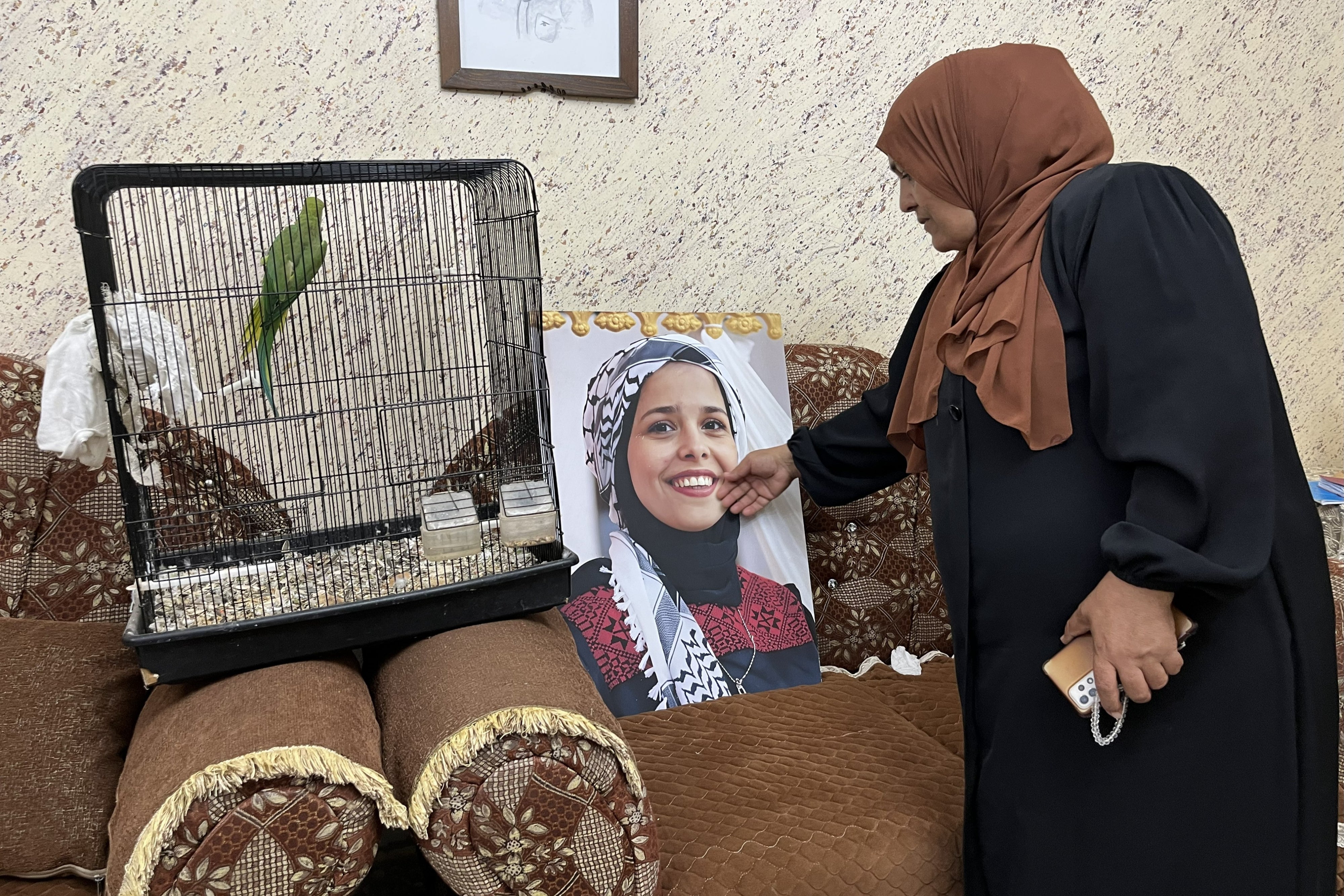 A woman touches a photo of a young woman