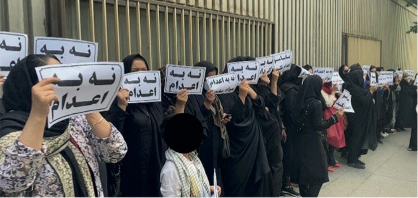 Family members of people on death row gather outside the judiciary building in Tehran, Iran, May 24, 2023, holding signs that read “no to executions.”