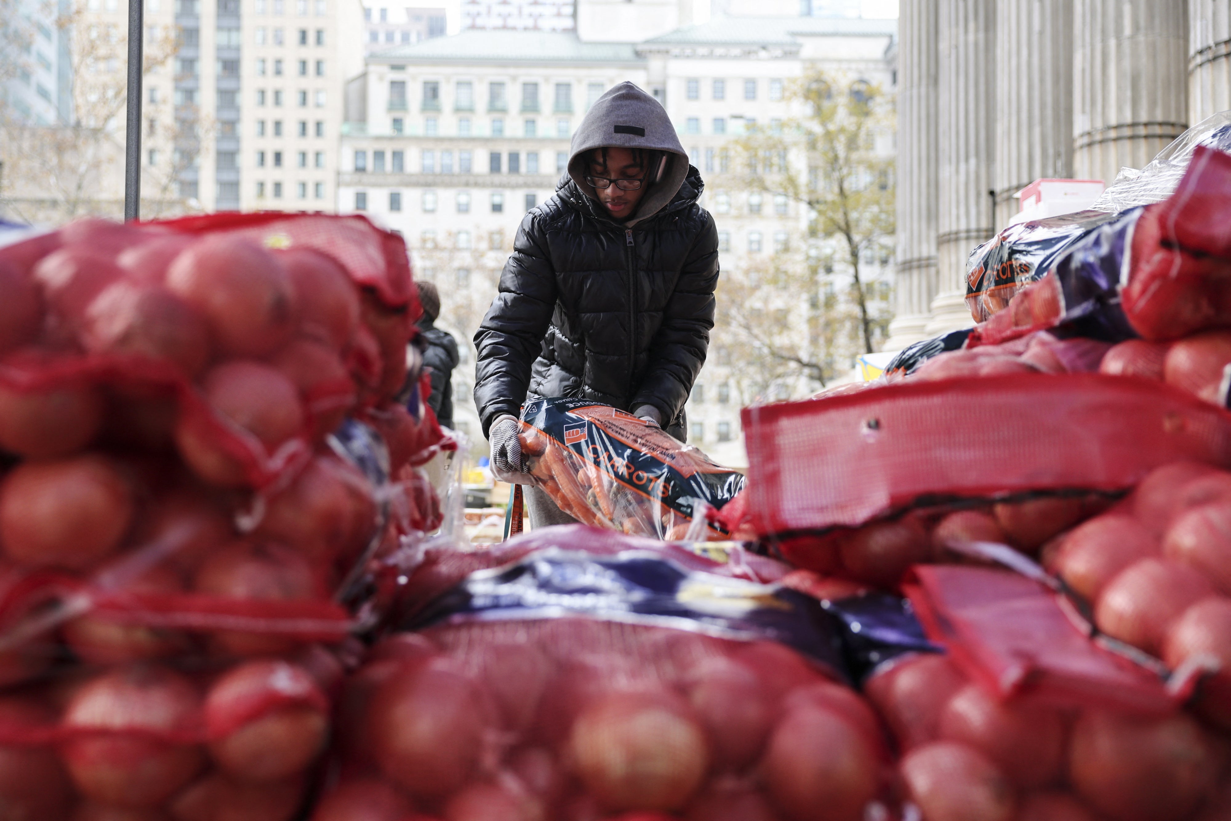 Um voluntário em um evento de distribuição de alimentos em frente ao Brooklyn Borough Hall, na cidade de Nova York, em 21 de novembro de 2025. 