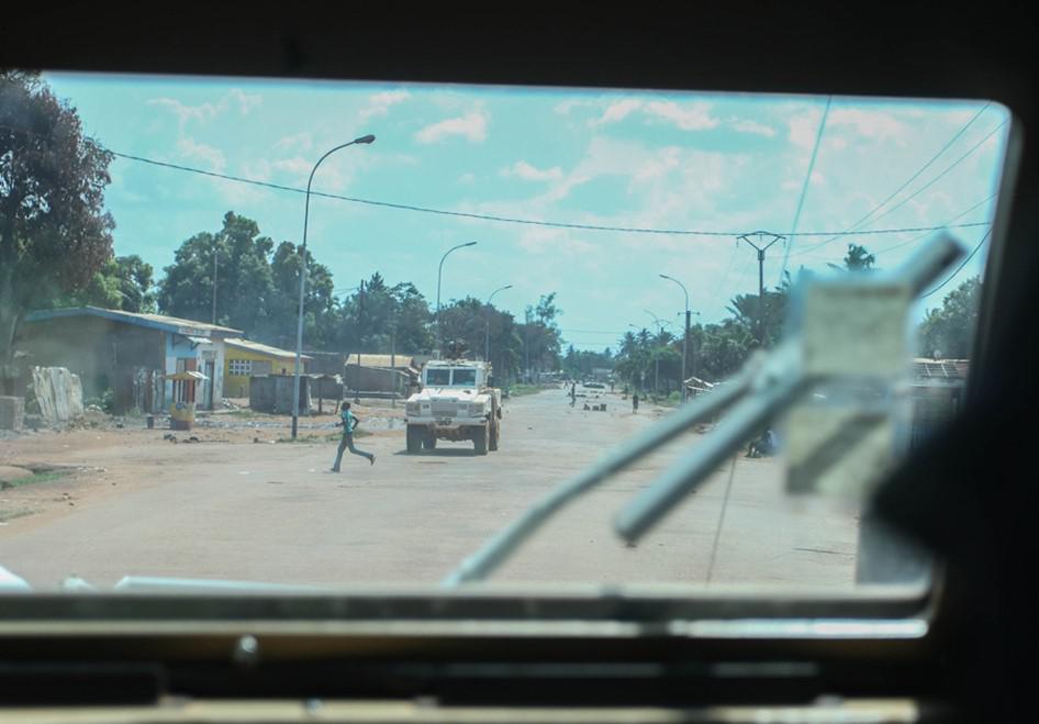 A boy runs in front of MINUSCA police on patrol in Bazanga quarter, Bangui on October 5, 2015.