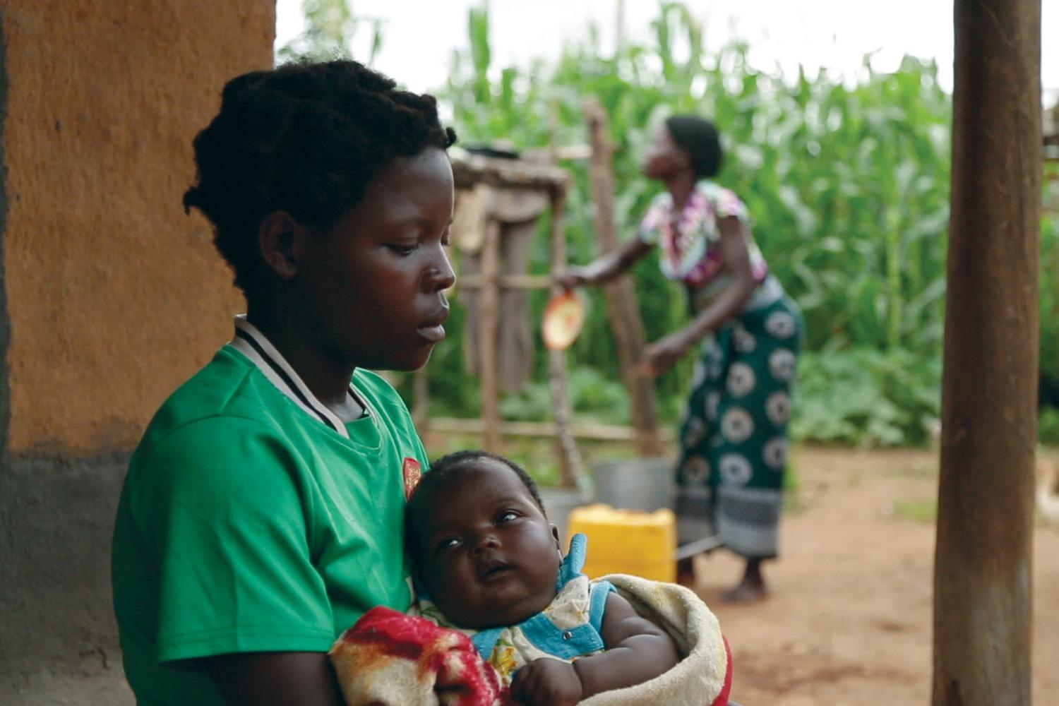 A 14-year-old girl holds her baby at her sister’s home in a village in Kanduku, in Malawi’s Mwanza district. She married in September 2013, but her husband chased her away. Her 15-year-old sister, in the background, married when she was 12.