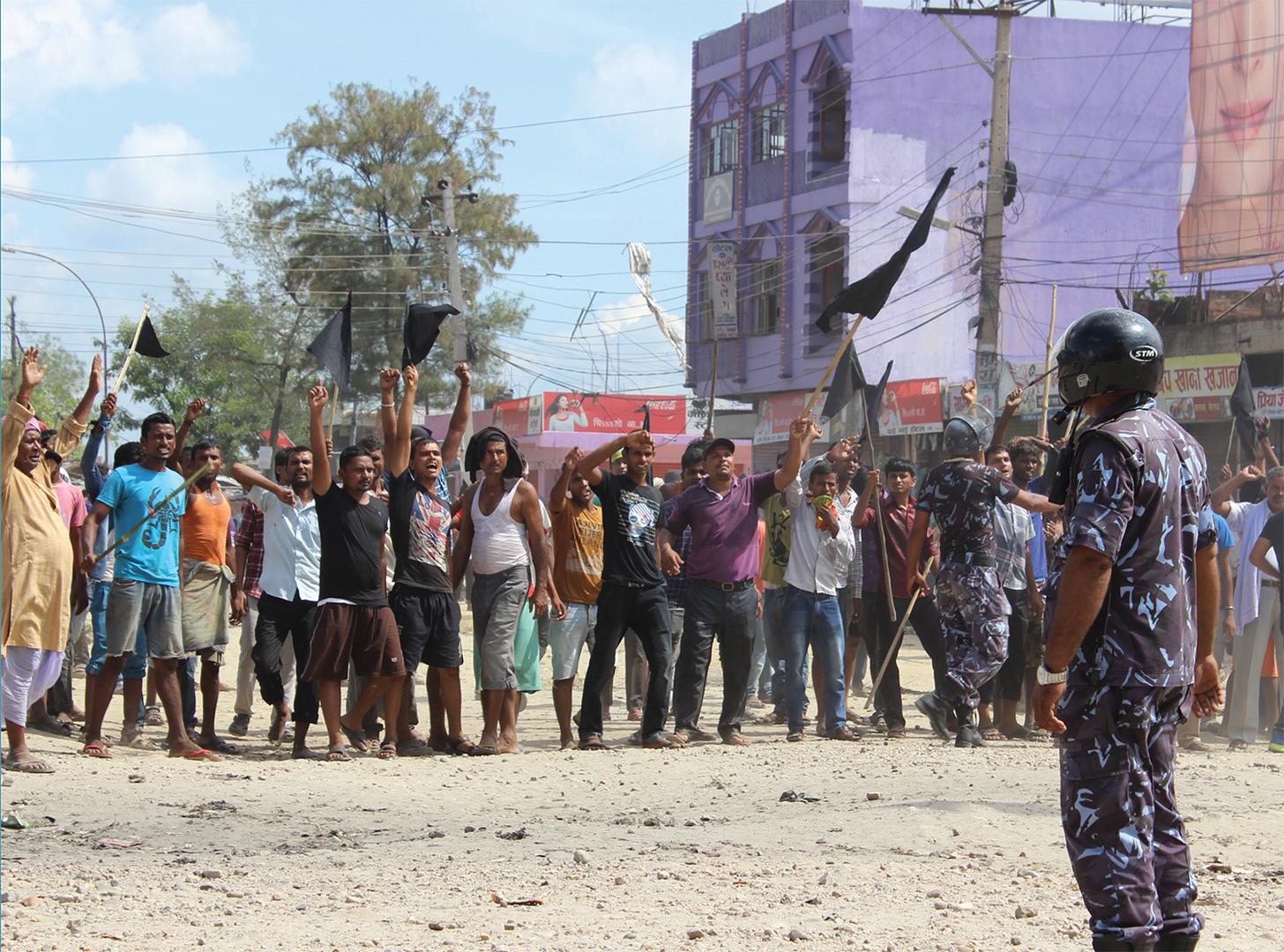A police officer faces protesters