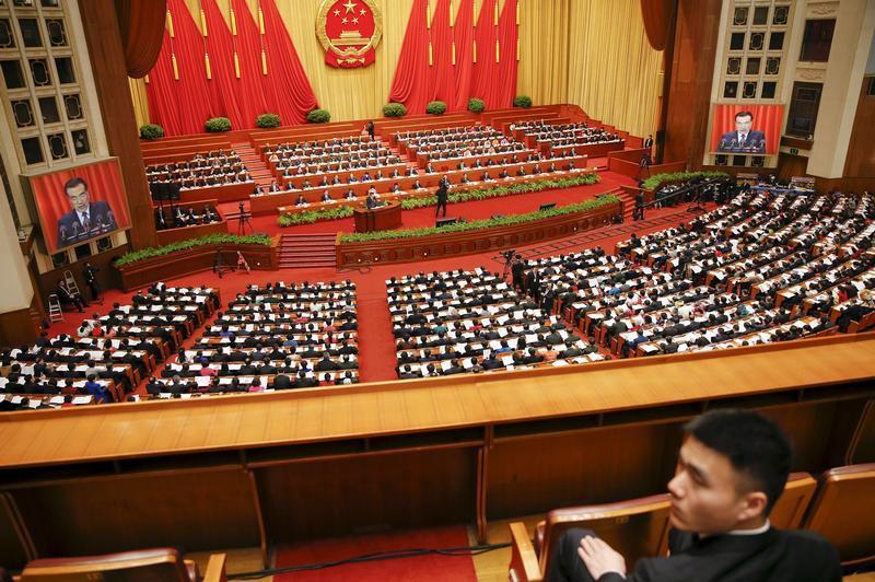 A security officer sits guard as Chinese Premier Li Keqiang gives a speech during the opening session of the National People's Congress (NPC) at the Great Hall of the People, in Beijing, China, March 5, 2016.