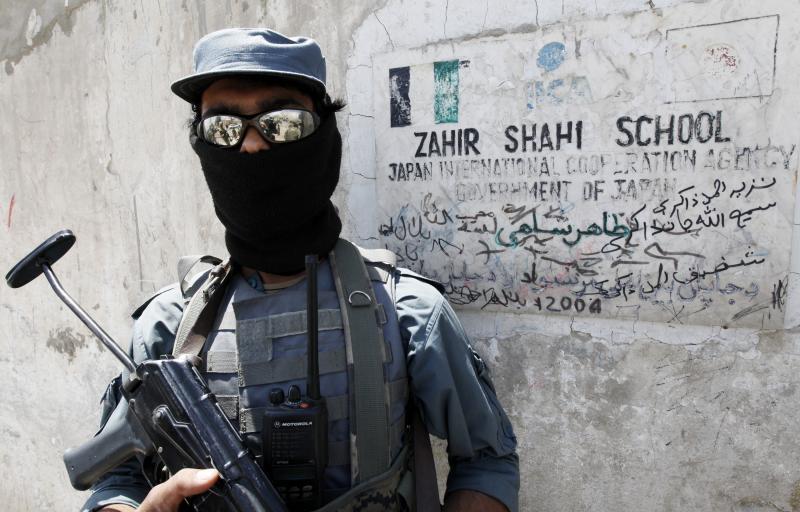 شرطي أفغاني يحرس مدرسة محلية ترعاها "وكالة التعاون الدولي اليابانية" في مدينة قندهار يوم 11 مايو/أيار 2010. 